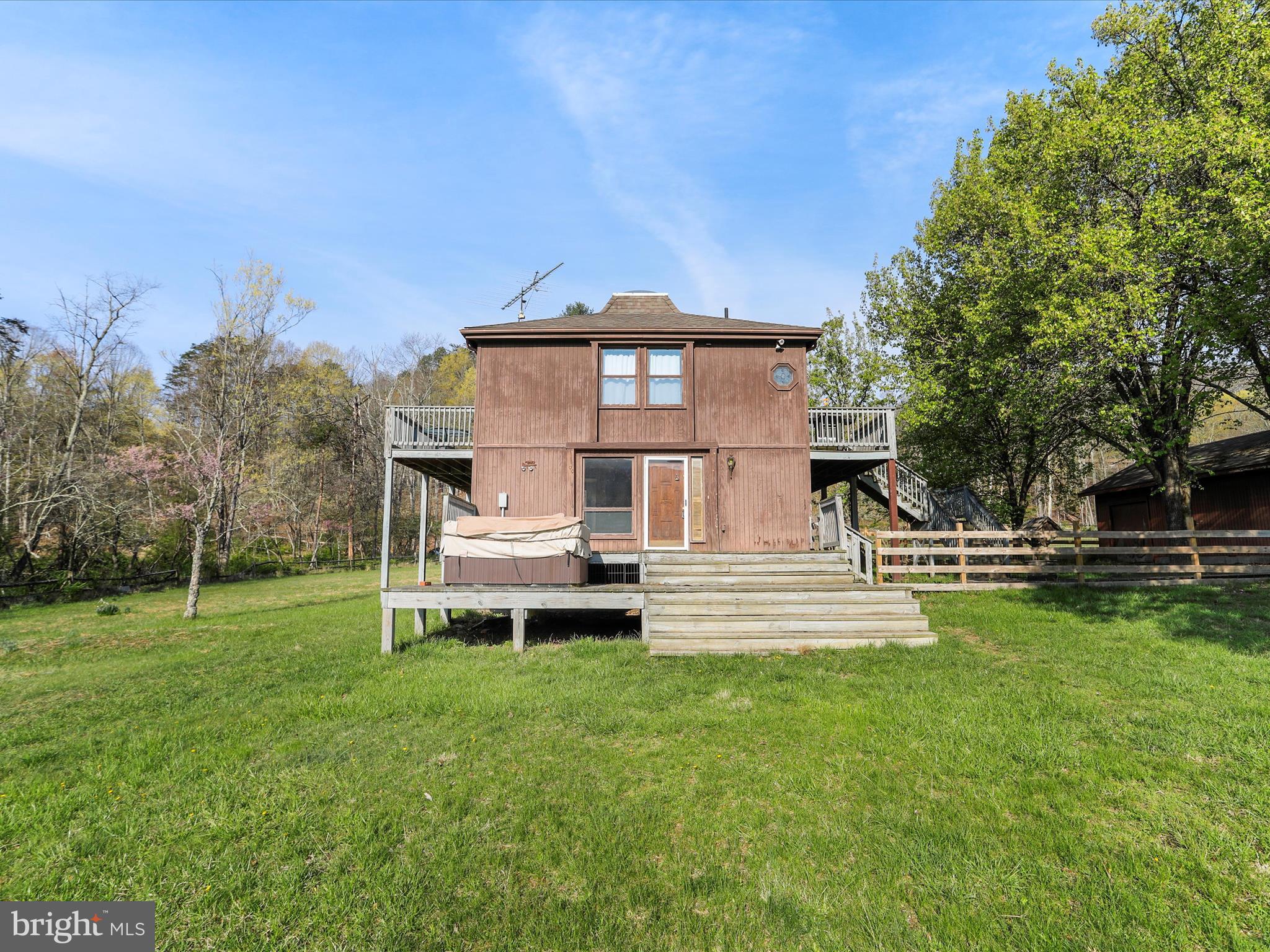 Enjoy your peaceful four-season home on 5 plus acres in the stunning mountains of West Virginia, just a short distance from the Cacapon River, in the desirable gated River Ridge Community, just 2 hours from DC and Baltimore. The home is one of the few homes that boast an unobstructed view of the magnificent Cacapon Mountain from the front deck. Within a short distance to the Cacapon River but not in a flood zone, the 5.61 acres of land has beautiful mature trees and landscaping. Two of the acres are a fenced meadow and the remaining 3+ acres are wooded.
This 3-bedroom, 1.5-bath home offers a rare blend of privacy, space, and potential. As one of the original first properties to be built in River Ridge, the home itself is in need of some TLC and updates, but it’s the perfect canvas for someone ready to bring their vision to life. Whether you're an investor, a weekend warrior, or someone looking to create a custom getaway, the possibilities here are endless. With heavenly views from the upper deck to the wood burning fireplace inside and access to the Cacapon, this home offers lots of possibilities! Enjoy evenings outside around the fire pit or relax in the recently serviced hot tub as you take in the views around you. The detached garage adds extra value and versatility — great for secure parking, storage, or transforming into a workshop, hobby space, or studio. Whether you're looking for a place to tinker, create, or just keep your tools and equipment protected, it’s a great bonus feature with tons of potential. Great opportunities to enjoy hiking, swimming, kayaking, fishing and the peaceful tranquility the home has to offer. Home is being sold as -is. Book your showing today!
