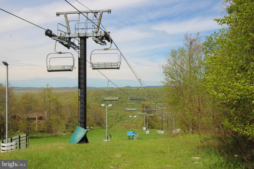 Build your mountain retreat on this rare, level, ski-in, ski-out lot off Ace's Run slope on Wisp Mountain (chair 7). With a slight grade, it's perfect for a variety of home styles while still offering a usable yard. Located just a half-mile from the ASCI Whitewater Rafting course and the 550-acre Fork Run Recreation Area, it’s a dream for year-round adventurers. Despite its peaceful, tucked-away feel, you’re just minutes from Deep Creek Lake's dining, shopping, and lake activities – ideal for both full-time living or a profitable vacation rental.