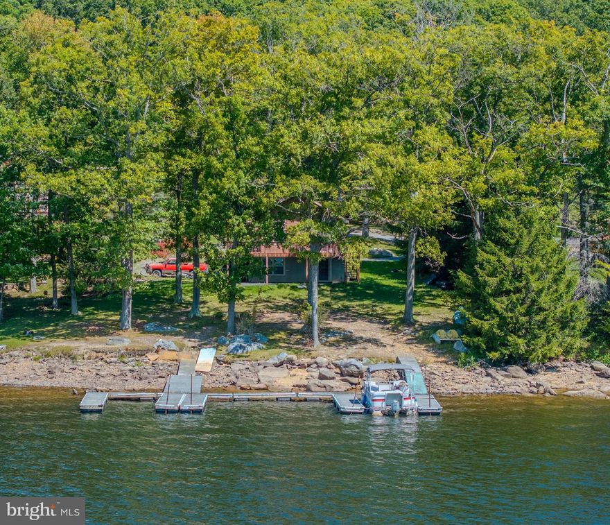 Lakefront! Type A boat dock. 100+' of beautiful, picturesque Deep Creek Lake frontage in prime central lake location. Gentle slope to good year-round water depth level part of lake. About as good as it gets. Easy, quick access off Rt. 219 and only 1 mile down County maintained Rock Lodge Rd.. 5+ mins. to Wisp. 5+ mins. to DCL State Park. No HOA. Beautiful lake frontage and view only approx. 50' from 2005 custom constructed ranch home on full walk-out foundation. Plenty of parking and tremendous lakefront yard area for recreation, landscaping, and full blown lakefront living and enjoyment. 3 bedroom, 2 bath house with L.R. & D.R. facing lake views with walk-out onto lake side decking. Large finished integral garage in portion of foundation/basement with remainder as walk-out basement on lakeside with unfinished rec. area and rough plumbing for future bath. House is and has been busy full-time residence, so could use a little cleaning and TLC, but nothing noted as significant.
