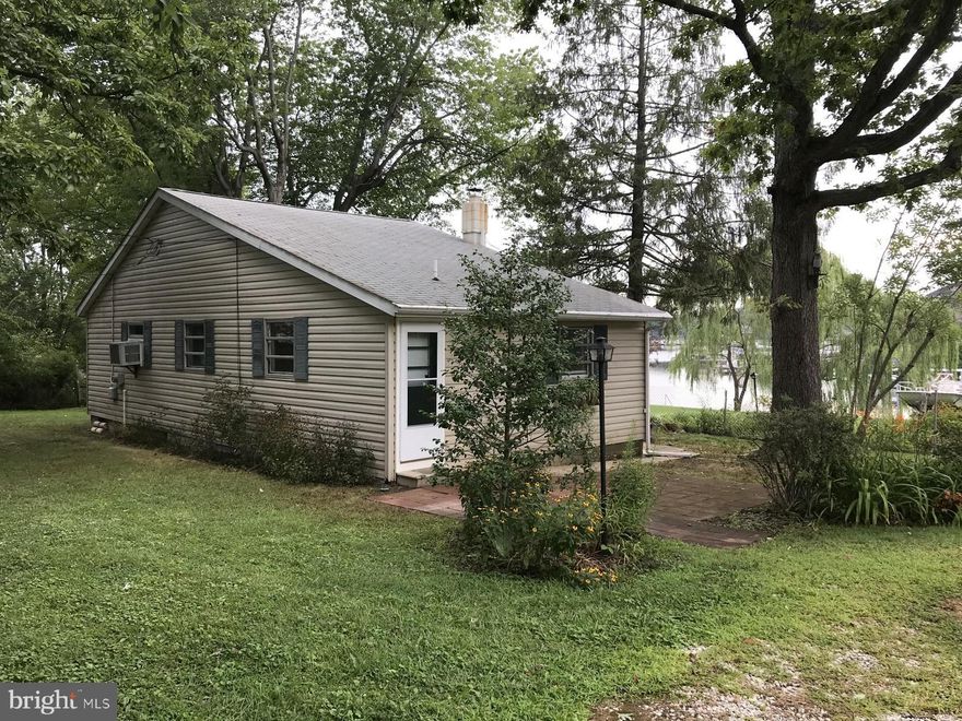 Water Views of Norman Creek from this Bungalow home established in 1913.  Bring the dogs to the incredible, level and fenced on 3 sides yard.  A rare opportunity to enjoy water views without the expense of waterfront. On a common right of way off Vogts Lane, the flowers and landscape is the first thing you see as you approach 413.  Turn into the homes drive way and you'll immediately see the water from the elevated site. Just under a quarter acre, there my even be room for expansion. The home is not waterfront but has plenty of places to put  your Adirondack chairs and enjoy the view.  Flood insurance is not required check FEMA MAPS. There's a 24x12 work/shed, and 15x13 patio. Enter through the mud room into the eat in kitchen. More water views from the Bedrooms and bath room windows. The living room and dining room combo allows several ways to arrange your furniture. The back of the home office, has an outside door. The cooking fuel tanks are leased. The home was once a licensed rental property. Priced under $150k , this will sell fast. Work being done on semi circle driveway to improve egress.
