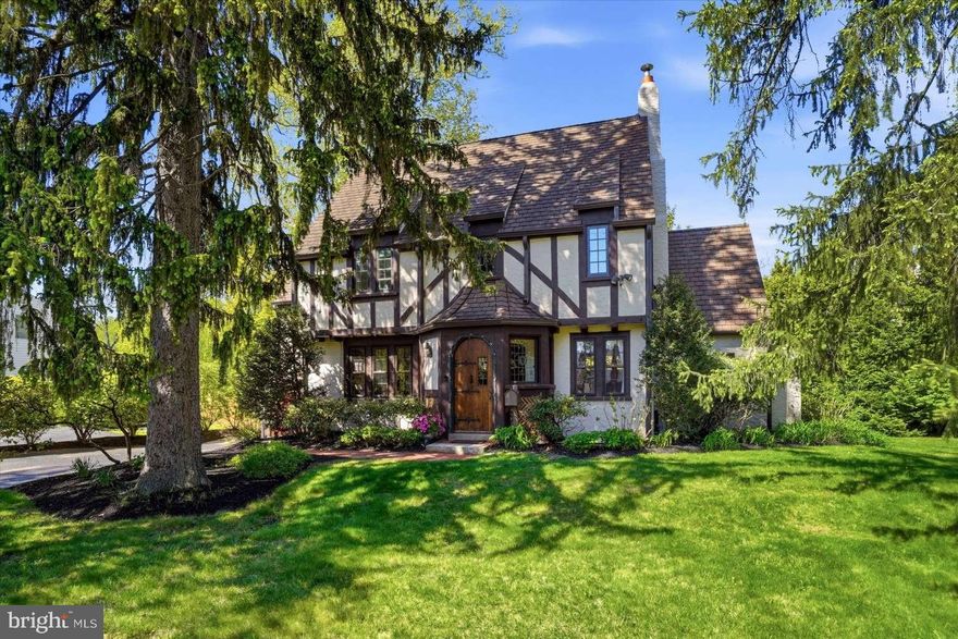 Elegant English Tudor style home on a beautiful, professionally landscaped property. Homes in this cluster of coveted properties rarely come on the market as owners hold onto them for decades. Walk a half block to commuter rail for a short ride to downtown Philadelphia or to many stops on the Main Line, east and west. Walking distance to a farmer's market, restaurants, and downtown Wayne, and close to many shops, libraries, parks, trails, nightlife, and grocers. Close access to many major highways. Top-rated Tredyffrin-Easttown schools and very low taxes. The stunning arched front door looks like it belongs on an English castle. A handsome, custom electronic garage door enables convenient entry into the house from inside the garage. The garage has a 240v outlet for EV charging and power tools. A spacious deck provides easy access from the kitchen for relaxation with privacy or for entertaining. Two staircases lead from the deck to the back lawn and to a large brick patio for barbecuing where there's plenty of space for a firepit. Paver walkways provide access to the deck and patio from the driveway. Security lighting along the entire perimeter of the house lights the way with motion detection as one steps from each zone into the next. Security cameras allow for photo capture as well. The eat-in kitchen has radiant heat in the floor and stainless appliances including an ultra-quiet Miele dishwasher, a recent 36-inch Wolf induction range and a recent Bosch refrigerator. Back stairs from the kitchen meet the main staircase for extra privacy. A full-size dining room allows for easy entertaining. A wood inlay star medallion in the floor transitions from a half bathroom, down several oak stairs to a tiled laundry room. Here are a recent top-rated washer and dryer with storage drawer pedestals as well as a utility sink. This laundry room has a door to the patio and also leads inside to the full-size unfinished basement. Off the living room is an enclosed porch/sunroom with large windows and room to accommodate an office setup. On the second floor, the primary bedroom with ensuite bathroom adjoins a second bedroom which can be used as a nursery, sitting room or office. Off the hall is another full bathroom as well as a bedroom with an adjoining bonus room. On the third floor is an ensuite bedroom/bathroom with an updated clawfoot tub. An additional bonus room has numerous possibilities. Stained glass windows in the front door and in the foyer, cast colors onto the walls in the sunlight. The house features significant natural lighting from the many windows which include singular styles characteristic of English Tudors. Professional perennial landscaping has something in bloom from late winter until late fall, providing significant privacy in the backyard and serene beauty all around the property. This is a very special property, boasting exceptional aesthetic desirability as well as convenient location.