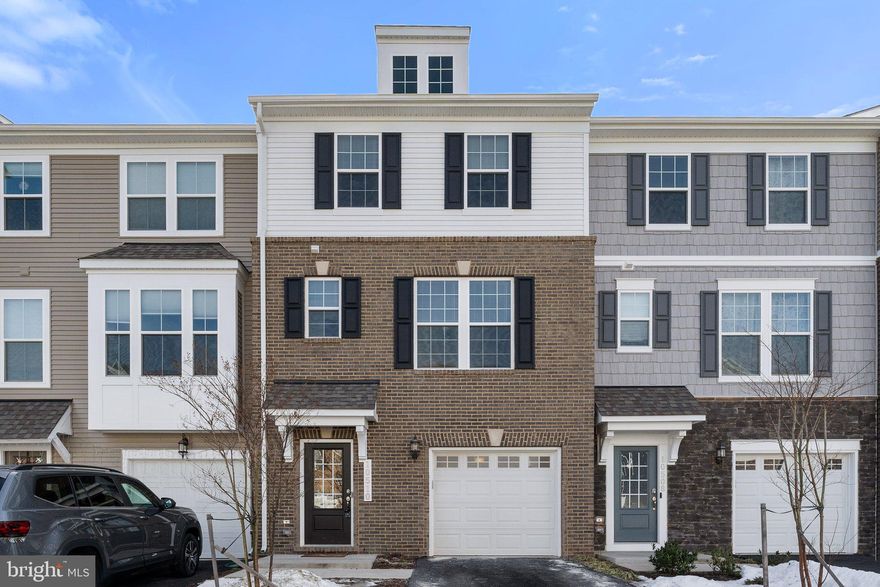 Welcome to this stunning Stanley Martin-built townhome in sought-after Bradley Square! Less than two years old and completely turn-key, this home offers modern style and convenience. Enjoy an open floor plan with main level 9-ft ceilings, recessed lighting, and beautiful finishes. The spacious kitchen boasts a 10-ft quartz island, breakfast bar, smart double wall oven, stainless steel appliances, and pantry. From stylish light fixtures to batten board, this home is truly captivating. With 3 bedrooms, 2 full & 2 half baths, there’s a bathroom on every level. The primary suite features a walk-in closet with built-ins, en suite bathroom with dual vanity quartz counters, and step-in shower.  15' x 6' deck off the kitchen. Attached garage with extra shelving for storage. Fiber optic internet is available. Community amenities include a splash pad, tot lot, lake, jogging path, pavilion, and more. Lawn care & trash included! Why wait for new construction? Schedule your showing today!
