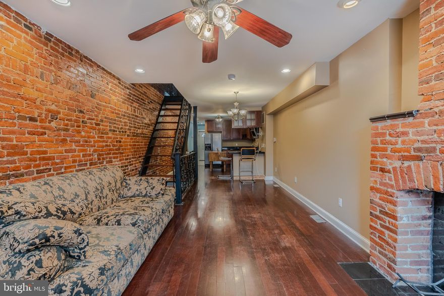 This hip and lovely townhome in the Washington Village/Pigtown neighborhood of Baltimore is available now! The construction here offers two beds and two baths (one full, one half) across its 1,911 total finished sq ft. The main floor interior has a classic straight-thru design with an open feel and has charming exposed brick walls, a brick fireplace that could be made functional, and recessed lights throughout. The open kitchen features plenty of great cabinets, countertop space, and modern appliances (including 5 burner gas range). As you approach the steps admire the beautiful metalwork railings. Upstairs, are the two bedrooms of the home, each with ceiling fans and closet space, and the full bath upstairs has a large corner soaking tub with solar tube above. One of the bedrooms includes access to a private raised deck with views of the M&T Bank Stadium! The finished basement of the property adds an additional 533 finished sq ft to the above-ground total and offers an awesome, multi-purpose room with built-in shelves and recessed lights. In addition to the raised deck, there is a covered parking pad in the back with lots of potential! Washington Village is a wonderful area of Baltimore to live, walk to the Raven Stadium, Camden Yard or the Inner Harbor and also close to the MARC station for an easy commute to DC. You are just minutes from downtown and with plenty of local amenities all around. Book an appointment today to check out this awesome urban outpost in Baltimore today!