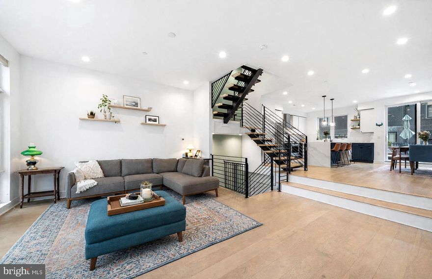 Welcome to 2512 E Cumberland Street, a rare 20 foot wide home offering the kind of space, parking, and livability that is increasingly hard to find in Philadelphia.

With a true two car garage and additional covered parking, this home stands apart from others in its price range. Approximately 7 years remain on the tax abatement, offering both immediate value and long term benefit. Proudly offered by the original owners, who purchased the home new in 2023.

Inside, the home opens to a bright and spacious living area with wide plank hardwood floors and open staircases that create seamless sightlines across multiple levels. The layout feels open without sacrificing function. The kitchen is set just above the main living area, creating a natural separation while still feeling connected. It features GE Café stainless steel appliances, custom cabinetry, an oversized island, pantry, and a first floor coat closet. Patio doors lead to a private balcony, perfect for outdoor dining or a quiet morning coffee.

A thoughtful upgrade by the owners expanded the staircase landings, adding usable square footage and improving the overall flow of the home. The second floor includes two generously sized bedrooms, one with an ensuite, both with large walk in closets. There is also a full hall bath, a spacious laundry room with sink and storage, and an additional living area that works well as a home office, den, or guest space.

The entire third floor is dedicated to the primary suite. This level includes two walk in closets and a skylight above the expanded landing that fills the space with natural light. A wet bar and additional half bath make entertaining easy, just steps from the roof deck. From here, enjoy wide open views of the Benjamin Franklin Bridge and the Philadelphia skyline.

The fully finished lower level adds even more flexibility with a full bedroom and bathroom, additional storage, and a functional drop zone with direct access to the garage. The combination of garage parking plus additional covered spaces is a rare find in the city.

The location offers easy access to neighborhood favorites and everyday conveniences. The open air garden along Cumberland Street hosts seasonal pop up markets just across the street. A short walk brings you to Coffee House Too, Benito’s Hardware, local grocery options, convenience stores, and Meetinghouse.

This home offers a combination of size, parking, and layout that is difficult to find at this price point in Philadelphia.

Select photos have been virtually staged to show potential furniture placement and use of space.