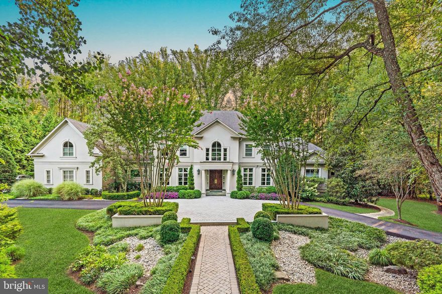 Introducing an exquisite French Provincial gem, serenely nestled in a wooded private oasis  – Welcome to 8295 Alvord. This masterpiece boasts a meticulously landscaped Charles Owen garden framed by graceful stucco architecture. As you step inside, prepare to be captivated. A grand Palladian window bathes the marble foyer in a cascade of natural light, revealing a majestic staircase that ascends to an upper-level mezzanine, offering a captivating vantage point overlooking the expansive double-height space.

At the epicenter of the home lies the regal central living room, adorned with arched windows and French doors that open onto the rear terrace. A fireplace with an oversized mantle serves as the room's focal point, accompanied by a resplendent crystal chandelier. The stately formal dining room, befitting a residence of this caliber, showcases intricate craftsmanship such as inlaid flooring, ornate crown molding, and designer fixtures. The gourmet kitchen features Clive Christian cabinetry, limestone flooring, and an array of high-end appliances by Wolf, Sub-Zero, and Miele. An adjoining mudroom is designed for functionality, replete with built-in cubbies, a family powder room, and access to the three-car garage.

The main-level primary suite offers a serene sanctuary with its neutral, calming palette. The marble ensuite bathroom boasts dual vanities, a separate soaking tub, a walk-in shower, and dual custom closets featuring cedar and ventilation. The elegant, paneled gentleman's library and inviting family room adjacent to the breakfast nook complete the main level.

Upstairs are three generously proportioned bedrooms with ensuite baths, and a guest apartment above the garage. The luminous, limestone-floored walkout lower level is perfect for entertaining, featuring a fully-equipped wet bar, temperature-controlled wine room, and a state-of-the-art private cinema with a 110-inch projection screen.

The outdoor living space is equally captivating, featuring a vast terrace, lap pool with an automatic cover, hot tub, covered loggia, and an Italianate fountain. A nine-foot fence encloses the 2.38 acres of flat, tree-lined land, ensuring security and privacy. The home is outfitted with superior amenities, including an audio/visual system, whole-house generator, and automated irrigation zones. Within an ideal location near Tysons Corner, downtown Washington, Dulles Airport, and access to top schools, 8295 Alvord is fitted for the most discerning of buyers. Showings require 24 hour notice with financially verified clients at seller's request.