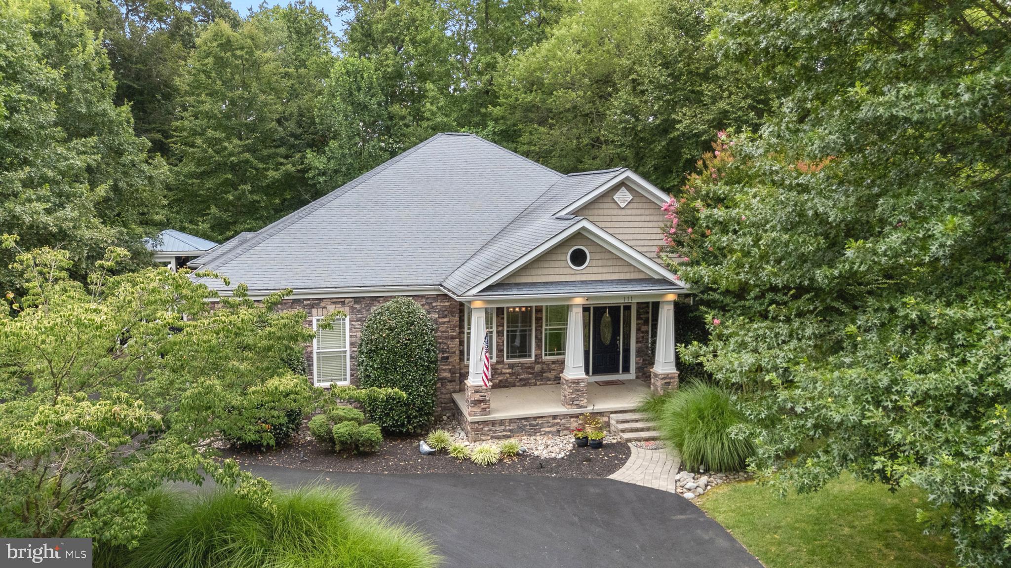 Welcome to this custom-built ranch-style masterpiece nestled in the peaceful Bethel Springs community in North East, MD. Offering the perfect blend of luxury, comfort, and entertainment, this 3-bedroom, 3-bathroom home is a great find. This home is 5 minutes from I-95, the PA border, and the town of North East. 111 Bethel Springs is the definition of a staycation. It all starts with the welcoming expanded circle driveway for ample parking.
Entering the home, you will be welcomed by an oversized open floor plan consisting of the dining room and living room areas. These rooms are surprisingly bright and airy. The gourmet kitchen is a true showstopper, featuring upgraded cabinetry accented by custom wood beam ceilings, an oversized peninsula, a center island with a butcher block top, and high-end appliances, including a Viking built-in range with griddle, double wall oven, and a Sub-Zero refrigerator. The open concept flows seamlessly into a spacious family room with a double-sided gas fireplace and a bright sitting room with outdoor views. Throughout the main level, you’ll find thoughtful architectural details such as arched entries, crown moldings, wainscoting, and 9-foot ceilings.
The open concept flows seamlessly into a spacious family room with a double-sided gas fireplace and a bright sitting room with garden views. Throughout the main level, you’ll find thoughtful architectural details such as arched entries, crown moldings, wainscoting, and soaring 9-foot ceilings. The primary suite is a serene private retreat with deck access direct to the hot tub, a walk-in closet, and a spa-like ensuite bathroom complete with a clawfoot tub and custom-tiled shower. Two additional spacious bedrooms and a full hallway bath complete the main floor. Step outside to your private backyard paradise. The expansive deck is ideal for entertaining and features a custom Tiki bar with a built-in TV, a hot tub, an outdoor kitchen and grill area, scenic tree-lined views, a landscaped yard, and even a horseshoe pit. Whether you're hosting a lively cookout or enjoying a quiet evening under the stars, this outdoor space is made for unforgettable memories. Maintain the yard easily with a sprinkler system. The entertainer’s dream basement offers over 1,200 square feet of finished space perfect for relaxing or hosting guests. Enjoy a game room with a built-in bar with complete plumbing, a kegerator, a movie screen area with cozy seating, and a den/home office that could serve as a fourth bedroom. This level also includes a full bath, an exercise room, and walk-out access to the side yard. Architectural highlights like stone and wood pillars and a stunning corner fireplace with a stone surround add character and charm. Everything in the basement is included, with the exception of the gym equipment, which may be negotiable. You can truly move right in and start your entertainment, including a pool table, table-top tennis/ping pong, as well as an upper and lower interior and exterior audio system. The home is serviced by public sewer and a private well. Situated on a 0.58-acre lot, the home was built in 2007 and offers a total of 3,815 finished square feet. Let's not forget about the oversized turned 2 two-car garage, or the added safety of the 9-camera security system. Schedule your private tour today and experience the one-of-a-kind charm of 111 Bethel Springs Dr. This isn’t just a home—it’s a lifestyle.