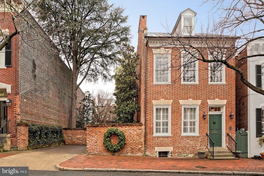 Nestled along one of Old Town's most cherished streets, 113-115 South Lee Street is a rare combination of a meticulously renovated 1790's residence plus an entire city lot 115 S Lee, which is a private garden offering unparalleled privacy.  This exquisite renovation showcases elegance with the finest craftsmanship, preserving original heart pine floors and maintaining all interior doors with authentic box locks. The home’s historical charm is further accentuated by intriguing, curved walls, a signature of the builder, William McVeigh.   Tall windows illuminate the double parlor living rooms with natural light and highlight the 10' ceilings.  Custom bookshelves and two fireplaces create a warm and inviting atmosphere.  A hyphen hall offers practical amenities such as a coat closet, wine racks, a beverage cooler, and additional storage.  The elegant dining room, with two windows plus French doors opening to the garden, provides an ideal setting for entertaining guests.  Exposed brick walls found in the half bath and in the kitchen framing the stove, add character and depth to the home.  The renovated kitchen is a chef's dream, featuring custom cabinetry, granite countertops, an eat-in area, garden access, and ample pantry storage complete this culinary haven.

The second floor features a versatile study or dressing room, enhanced by a cozy gas fireplace framed with custom cabinetry. The primary suite is a serene retreat, boasting heart pine floors, a unique curved wall, and a custom walk-in closet with additional storage. Enjoy the convenience of a Miele stackable washer and dryer within a large closet, complemented by extra cabinetry. The luxurious primary bath includes a seamless glass shower with marble basketweave accent tile, heated floors, and a quartz-topped vanity.

A sunlit hallway office creates an inspiring workspace, while the expansive family room, with its trio of windows, invites relaxation. Enjoy the warmth of a gas fireplace and showcase your treasures on the built-in shelving, featuring lighted glass display cabinets and open shelving. A well-appointed wet bar with a granite countertop, beverage cooler, and under-cabinet lighting makes entertaining a breeze. A full bath on this level offers heated marble floors, a clawfoot tub, and an apothecary sink.

The third level offers three additional bedrooms and two full baths. The front guest suite impresses with heart pine floors, eave storage, and a full bath with a seamless glass shower and marble flooring.  Two rear bedrooms, including one with a Murphy bed, share a Jack-and-Jill bathroom with a sleek glass shower, offering both functionality and style.  The basement provides ample storage with waterproof walls and an epoxy concrete floor.

The redesigned garden at 115 South Lee, crafted by landscape architect Joan Honeyman, is a masterpiece featuring two water elements, copper-clad trellises, terraced steps, upper and lower patios with a wood pergola, and custom lighting. An irrigation system ensures lush greenery throughout this private sanctuary. Additional highlights include audio speakers on the main level, family room, and garden, Kolbe windows, five new exterior doors, and copper roofs, gutters and downspouts, plus a new garden shed.  One off-street parking space completes this exceptional property.  Experience unparalleled privacy in this historic gem, where modern luxury meets timeless elegance.