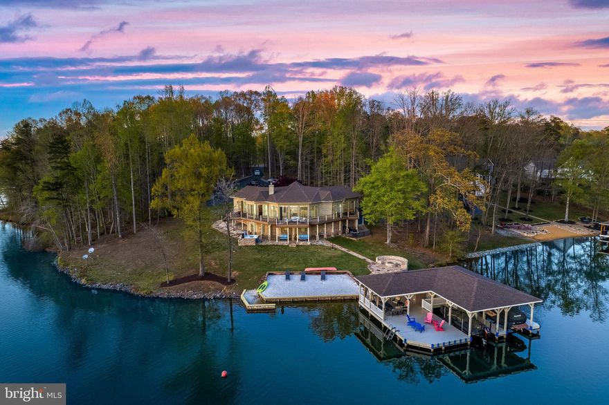 This timeless waterfront beauty spans 4880 sq. ft. and presents a fantastic opportunity for short-term rentals. Featuring an open floor plan, this contemporary home offers both luxury and functionality.

Inside, you’ll find six spacious bedrooms, one den, three full bathrooms, and two powder rooms. Expansive sliding doors lead to a wraparound lakeside deck from every room, offering breathtaking views of Lake Anna. The dining room and family room boast soaring 15-ft ceilings and a double-sided stone fireplace that opens onto a sundeck.

The open-concept kitchen, living, and dining area is designed for both entertaining and everyday living, with 15-ft high ceilings that create a spacious and airy feel. The gourmet kitchen is a chef’s dream, featuring a center island with a built-in farmhouse sink, additional seating, and luxurious countertops. High-end appliances include a Sub-Zero refrigerator and a Viking cooktop. A cozy breakfast nook provides the perfect spot for casual meals. Ample storage space and a walk-in pantry complete this impressive and functional kitchen.

The luxurious master suite overlooks the lake, offering a private retreat where every detail has been meticulously considered. The primary bedroom is bright and airy, with 15-ft high ceilings, a skylight, generous built-ins, and a spacious closet. The master bath features double sinks and an oversized shower.

Every room in this home is spacious and designed to feel like a private suite, creating a comfortable and inviting retreat.

The expansive lower-level walkout offers incredible recreation space, including three bedrooms, one den, a full bathroom, and a powder room. Additional highlights include a large family room with built-in shelves and a recreational area.

Step outside to 250 feet of bulkheaded waterfront, complete with your own private sandy beach, a stone patio with a fire pit, and a covered boathouse. The boathouse features two slips with electric lifts, a storage room, a tiki bar, a sundeck, and a jet ski pad. Additional outdoor amenities include an outdoor shower, a spacious composite deck, and a paved driveway leading to an expansive patio—perfect for enjoying Lake Anna’s natural beauty.

With deep water, panoramic views, riprap shoreline protection, a boathouse, and a deck, this property is a haven for water enthusiasts. The fire pit enhances the outdoor living experience, making every evening by the lake unforgettable.

From sunrise to sunset, the beauty of Lake Anna surrounds you, creating a true retreat.

This is an incredible opportunity to own a move-in-ready custom home on Lake Anna. Schedule your private showing today! The home includes numerous major upgrades. Please get in touch with the listing agent for a complete list.”

With so many delightful features, this dream home won’t last long!

📍 Located in the Cuckoo’s Nest subdivision on the private side of Lake Anna. Don’t miss out!