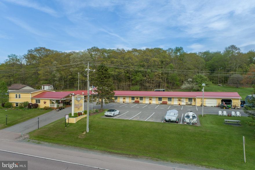 Prime Commercial Opportunity – The Garrett Inn 5.76 Commercial Acres Near Deep Creek Lake!
Exceptional commercial investment opportunity featuring The Garrett Inn, a well-established and immaculately maintained 10 Room motel property just minutes from Deep Creek Lake’s year-round recreation. The property includes a beautifully kept 3-bedroom, 1.5-bath owner’s residence (could also be rented out if the new buyer's do not need to live on property) and attached motel office, offering a spacious kitchen, dining area, and lower-level family room. The residence connects directly to 10 spacious motel guest rooms. Each tastefully decorated and fully equipped with large TVs, mini-refrigerators, coffee makers, and full-size bathrooms. The motel enjoys over 80% occupancy, reflecting its strong reputation and consistent demand. Guests benefit from a centrally located ice and refreshment room, while the property also features a separate 2-bedroom 1-bathroom rental cottage for additional income.
Situated on 5.76 acres, the property offers approximately 4 acres of undeveloped land behind the motel, creating outstanding commercial expansion potential—ideal for short-term rental cabins, additional motel units, storage units or potential lot development (subject to local zoning approvals). Additional features include two detached garage/storage buildings and a highly convenient location with restaurants and shopping directly across the street. A rare opportunity to own an established hospitality property with strong income, expansion potential, and prime access to Deep Creek Lake attractions.