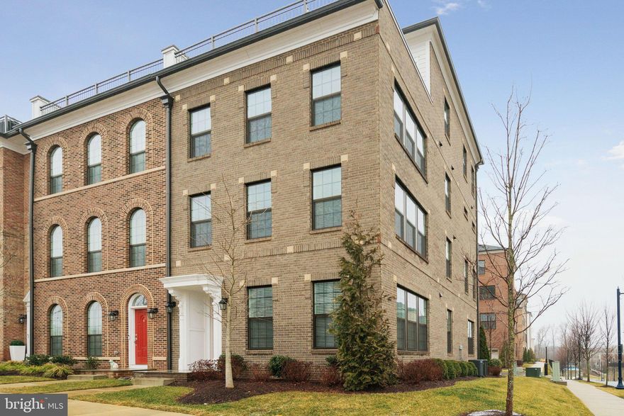 From its gourmet kitchen to its spa-inspired en suite, this home is poised to steal your heart.

Some homes simply look beautiful in photos. Others create a feeling the moment you step inside—a sense of calm, light, and possibility that makes you instantly imagine your life unfolding there. This remarkable corner residence in Potomac Overlook at National Harbor is one of those rare homes.

Built in 2023, this four-level contemporary brick residence is designed to feel open, bright, and effortlessly comfortable, with thoughtfully designed living spaces throughout. Being a corner unit makes all the difference. Extra windows wrap the home in sunlight from morning to evening, filling each level with warmth and creating the kind of natural light that instantly lifts the mood of every room.

Step inside and the experience begins with beautiful light gray wood flooring, recessed lighting, and clean architectural lines that give the entire home a fresh, modern feel.

At the heart of it all is the stunning white gourmet kitchen—a space that feels both elegant and welcoming. Crisp cabinetry, striking marble countertops, a large center island, and premium stainless appliances create a kitchen that is as functional as it is beautiful. The kitchen opens seamlessly to the dining and living areas, allowing the entire main level to feel open and vibrant.

The living room is equally inviting, anchored by a sleek gas fireplace and surrounded by windows that bring the outside in.

Across its four thoughtfully designed levels, the home offers three spacious bedrooms and three-and-a-half baths. Each bedroom feels private and comfortable, with generous proportions and abundant natural light. The primary suite is especially impressive, offering the feeling of a true retreat.

The primary bathroom, inspired by the model-home design, feels more like a spa than a typical bath. Clean lines, elegant finishes, a soaking tub, and a large glass shower create a calming space where everyday routines feel elevated. A custom walk-in closet completes the suite with thoughtful organization and plenty of room for everything.

Additional living space throughout the home offers flexibility for work, hobbies, media, or relaxation.

From the elevated outdoor spaces and expansive windows, the scenery unfolds in a way that feels almost cinematic. The skyline of Washington, D.C., the graceful span of the Woodrow Wilson Bridge, the vibrant lights of MGM National Harbor, and the iconic Capital Wheel create a backdrop that changes beautifully from sunrise to evening glow.

Life here also means being surrounded by the energy of National Harbor—a destination known for its waterfront experiences, dining, entertainment, and vibrant atmosphere along the Potomac.

Practical details round out the home’s thoughtful design, including a rear-entry two-car garage, modern systems, and contemporary construction completed in 2023, offering the confidence and efficiency of a nearly new residence.

Yet beyond the architecture, finishes, and location, what truly stands out is the feeling this home creates. The natural light. The openness. The quiet luxury of spaces designed to be both beautiful and livable.

**Taxable SqFt 4,152 which includes rooftop terrace and 2 car garage. But true total is 3,695 SqFt**