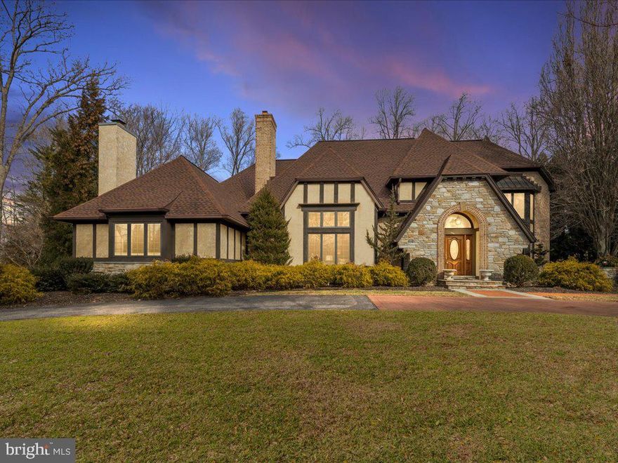 Nestled in sought after Laurelford, this stunning Tudor-style home exudes timeless elegance and features versatile living spaces blending the charm of historic design with modern flexibility.   The storybook exterior features pitched gable roofs, decorative half-timbering, beautiful stone and traditional stucco.  The inviting entrance through an arched doorway leads to a stunning two-story foyer with a sweeping staircase, upgraded flooring and custom wood trim and railings.  The great room features a two-story stone fireplace, hardwood flooring, beamed ceilings and a convenient beverage center.  A main level office with rich wood paneling, coffered ceilings, built-ins and a gas fireplace is the perfect spot for a remote workplace.  The chef's kitchen features upgraded countertops, a built-in Sub Zero refrigerator, five burner cooktop with downdraft, dual dishwashers and a sunny breakfast area.  Entertain in the impressive dining room with vaulted ceiling and a wall of windows, seamlessly connecting the interior and exterior living spaces.  The main level primary bedroom features hardwood flooring, a custom walk-in closet and a sitting area with French doors to a private patio.  The spa-like primary bath features double vanities, a soaking tub and a large steam shower.  Upstairs you will find two bedrooms, both with new hardwood floors and both featuring en-suite bathrooms and ample closet space.  The bonus room with skylights, two walk-in closest and new carpet is a great option for an additional bedroom.  The versatile lower level is ideal for extended living areas or multigenerational needs and has a separate, side entrance. The lower level living room features a wood burning fireplace and built-ins.  A kitchenette offers ceramic flooring, wood cabinetry and a stainless steel refrigerator.  The private bedroom features a walk-in closet and a full bathroom. Two additional rooms are ideal for another home office, hobby room or home gym.  A circular drive is perfect for guest access while the side-entry, three car garage will protect cars from weather and has plenty of room for storage or a workshop.  Relax on the private courtyard patio overlooking the fenced yard with a perfect combination of mature trees and grassy areas for play.  This home features many recent updates including a new roof in 2024 with a 50 year warranty, well pump in 2024, new water heater in 2024, new water softener/neutralizer in 2024,  upper level hardwood flooring and carpet in 2024, new washer and dryer in 2024,  five zone heating and cooling and more.