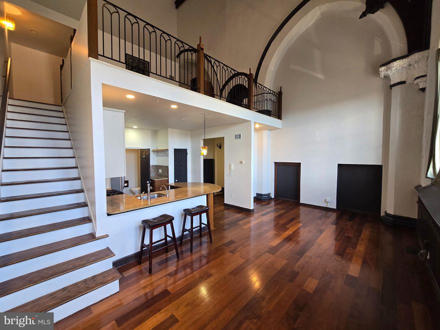 Available now! This unforgettable 1 bed, 1.5 bath loft is housed in a striking converted 1905 church, blending dramatic architectural details with sleek modern living. Enjoy the convenience of onsite, covered garage parking for an additional $200.00 per month. Sunlight pours through oversized stained glass windows, illuminating soaring 25+ foot ceilings, rich hardwood floors, and an open-concept kitchen with stainless steel appliances and generous storage. Just off the kitchen, you’ll find a powder room and laundry closet. The main living area is a showstopper from every angle, with the living room crowned by a vaulted, cathedral-like ceiling. Upstairs, the lofted primary suite offers a spacious layout, a full bath, and views overlooking the grand living space below. Steps from Wissahickon Station and only minutes from Main Street’s cafes, pubs, and riverfront trails, this one-of-a-kind rental is simply not to be missed.