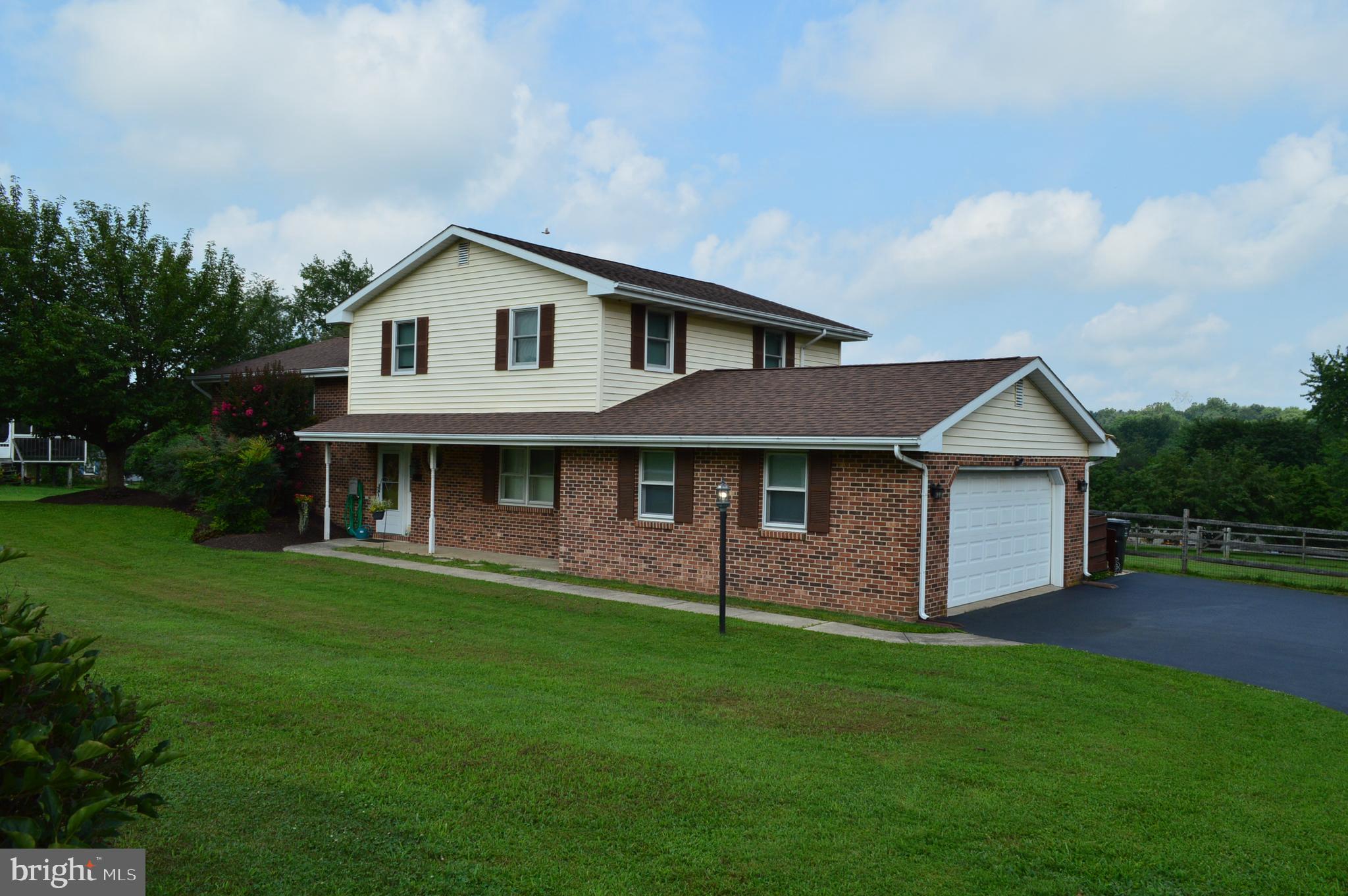 Welcome to this well constructed and maintained brick 3 bedroom, 2.5 bath split level home on a fenced 1 acre lot. This home invites you past the covered porch and into the tiled atrium. On this floor, you will find a large light filled family room with a fire place, new carpets, and access to the rear patio where morning coffee can be enjoyed. There is also a large, newly carpeted room that was previously an office and 4th bedroom. A powder room completes this floor. Up one flight, you'll find a lovely living room with an open flow into the dining room, both with beautiful wood flooring. An Pella sliding glass door provides access to the rear elevated deck,
to watch the beautiful country sunsets. The eat in kitchen is spacious with stainless appliances and a skylight that allows plenty of natural light. The top floor has beautiful wood flooring, a primary bedroom with its' own en suite and walk in closet. Two nicely sized bedrooms and a hall bath complete this floor. The dry daylight walkout basement,provides plenty of storage or can be finished for additional living space if desired. Newer mechanicals include water heater, well pump, and hvac units.