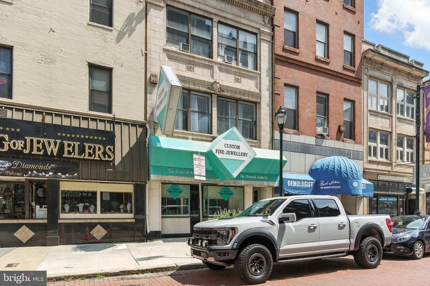 735 Sansom Street offers fee simple interest in a mixed-use property located in the heart of Philadelphia’s historic Jewelers Row. The asset features two spacious two-bedroom, one-bath apartment units along with 1,000 square feet of prime street-level commercial space.

The apartments present a comfortable and functional layout, with separate living, dining, and sleeping areas. Large windows bring in natural light, while well-proportioned rooms provide flexibility for furniture placement. New ownership has the opportunity to fully reposition these units by updating kitchens, bathrooms, and flooring, unlocking significant rental upside over current in-place rents.

The ground-floor commercial space sits in a location known for decades as the center of Philadelphia’s diamond trade. This 1,000-square-foot retail storefront has hosted numerous successful jewelry businesses and is surrounded by industry icons. New ownership can occupy the space immediately or lease it to one of the many entrepreneurs eager to join this thriving corridor.

Sansom Street is currently experiencing a wave of transformation, with Pearl Properties set to deliver a Class A residential tower at 7th and Sansom. This development will bring increased foot traffic and new clientele to an already vibrant location.

The property is transit-oriented, offering easy access to I-76, I-676, and I-95. The SEPTA Regional Rail station at 8th and Market is just a short walk away, connecting tenants to Center City, University City, and the Philadelphia suburbs via the Market-Frankford Line. Residents and business owners alike enjoy all that Center City Philadelphia has to offer, right at their doorstep.