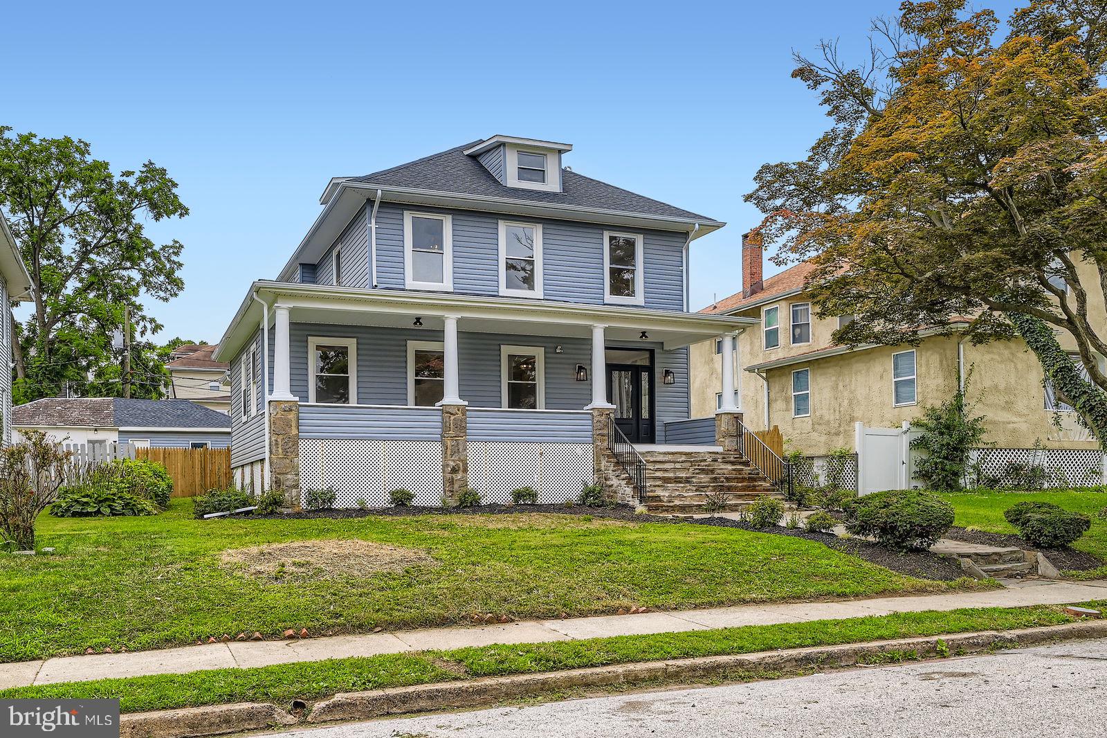 A stunning Colonial standout in historic Ashburton — 7 bedrooms, 5.5 baths, a two-car garage, and 6,050 finished square feet of beautifully rebuilt living space. Taken down to the subfloors and fully reimagined with over $300,000 in upgrades, this home offers brand-new electric, plumbing, dual-zone HVAC, roof, windows, insulation, and siding — delivering modern comfort with timeless charm. Located just three houses from peaceful Lake Ashburton, you’ll enjoy easy access to walking paths and green space. The classic blue exterior pops with crisp white trim and a stately front door, framed by a flagstone walkway and staircase and a 35-foot-wide full-length covered front porch — perfect for morning coffee or evening relaxation. Inside, the main level features 9-foot tray ceilings, recessed lighting throughout, and European white oak-style luxury vinyl plank flooring. The spacious 31' x 21' living room with powder room flows into a dining area measuring over 13' x 14', and into a show-stopping kitchen with white shaker cabinets, granite countertops, designer tile backsplash, and stainless appliances. A peninsula-style island connects to the main living area, ideal for hosting or keeping an eye on kids. A built-in bar area with charcoal-toned glass-front cabinets and wine rack adds contrast and elegance. Throughout the home, matte black finishes on door hardware and bath fixtures tie the design together. A main-level bedroom with ensuite bath provides flexibility for guests or multigenerational living. Off the kitchen, step onto a private rear deck that overlooks a brand new privacy-fenced backyard measuring 50' x 50', perfect for outdoor play and entertaining. A two-car garage is easily accessed via a wide alley. Upstairs, the primary suite offers a 10' x 7' walk-in closet, spa-style bath with soaking tub, marble-tiled shower, dual vanities, and a private balcony facing the backyard. The second bedroom is nearly primary-sized with its own bath and deep closet. The third and fourth bedrooms include large closets, ceiling fans, and recessed lighting. The third floor is a bright and spacious bonus area or 7th bedroom — ideal for a playroom, office, or creative studio. The fully finished lower level includes high ceilings, a 6th bedroom with ensuite bath and private entrance, plus utility and storage space. A full perimeter drainage system ensures the space stays dry and functional year-round. Wide-plank flooring continues downstairs for a seamless finish. This extraordinary home offers scale, finish, and flexibility rarely found in the city. A true Ashburton gem, rebuilt for modern living.
