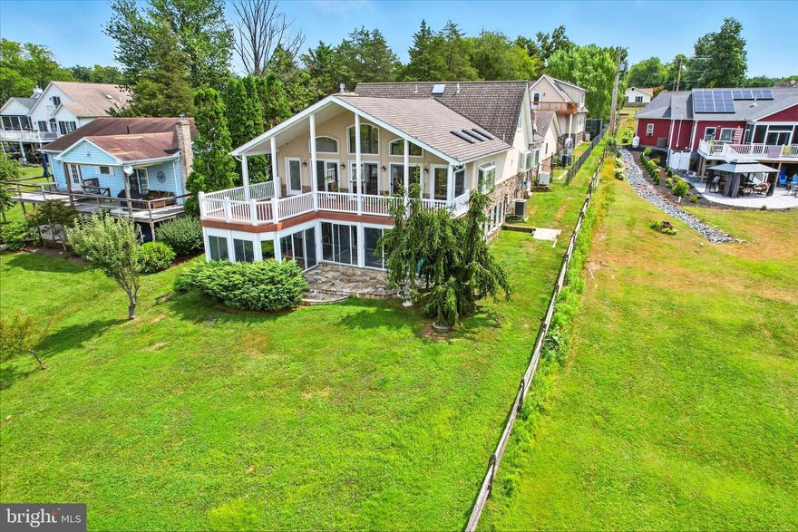 Very rare Lake Heritage lakefront listing with 5464 sqft of living space in main home, plus charming 1 bedroom apartment over 4 car detached heated garage with 3 gorgeous wooden carriage doors.  Including apartment, this home offers 6 bedrooms, 4.5 baths.   Enter a  tree-lined driveway to front door, where main level includes huge great room with floor-to-ceiling stone-front gas fireplace, upgraded kitchen/dining area, family room with gas fireplace,  rec room , 1/2 bath and primary bedroom with full artistically-painted and tiled primary bathroom, all with a stunning lake view!  Second level has 2 bedrooms and 1 brand new  beautifully tiled full bath.  Lower walk-out level has yet another rec room, with gas stove,  2 more bedrooms, a den and another brand new upgraded full bath. Upper level composite deck looks out over lake and under it is a 3 season sunroom  complete with hot tub.  Apartment has cathedral ceiling and open floorplan, with bedroom area, living area, with gas stove,  full bath and kitchenette area.  Dock comes complete with a lift.  Be sure to check out the storage area accessed from the the middle outside door on front of house, as well as the huge storage closet in great room and huge storage area accessed from 3 season room.  Lake Heritqge, conveniently located just off Rts 15 and 97 for easy access, includes a 150 acre lake for water skiing, fishing, boating of all kinds, olympic-sized pool right on the lake, community center, playgrounds, pavilions, dog parks, walking trail, basketball court, beach volleyball, tennis/pickleball court, clubs and more.  This is a must see for the discerning buyer!