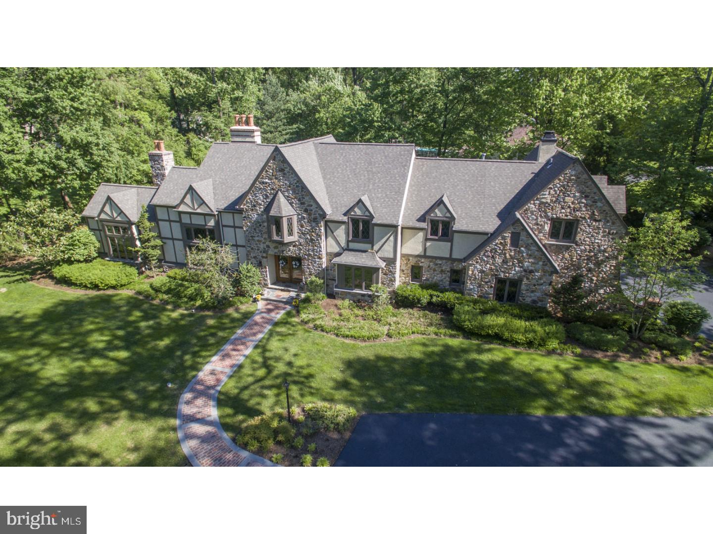 Must see renovated English Tudor home filled with abundant light, graceful rooms, a layout conducive to entertaining, and finishes of the finest quality. This grand 5 bedroom beauty with 4 full baths & 3 powder rooms sits on 3/4 acre of professionally landscaped grounds. Enter the home from the brick lined circular drive & flagstone walkway into the welcoming foyer. Flanking the front foyer are open views to the formal living and dining room, each enhanced with extensive mill-work and hardwood floors. In the formal living room you find two-story vaulted beamed ceiling, floor to ceiling windows, fireplace, and built-in shelves. From there pass through the elegant double doors into the large cherry-paneled wainscoted office with fireplace, bookcase wall, triple window and wet bar w/frig. The casual entertaining areas are at the back of the home. Magnificent gourmet kitchen with custom cabinets, wide plank chestnut floors, granite counters, large carrera marble island w/seating, Viking 6 burner range and wall oven, Sub-zero frig, handmade tile back-splash, built in butler's pantry and more! Adjacent to the kitchen is the herringbone brick mudroom complete with walk in pantry, desk area, and large laundry room. From the breakfast area you find the formal powder room and spacious family room complete with stone fireplace, custom built-ins and triple slider to backyard. The backyard is the ultimate entertaining area, with an expansive limestone patio, black bottom pool, stone fireplace, and outdoor kitchen with Dacor gourmet grill...all in this beautiful fenced backyard. Upstairs is a custom library balcony overlooking the formal living room. On the second floor is a large master suite with vaulted ceilings, travertine marble gas fireplace, two walk in closets and spacious en-suite travertine marble bath with luxurious glass shower, jetted heat controlled tub, double vanities, water closet, and heated floors. Four additional spacious bedrooms, two with tiled en-suite baths and a large hall bath with custom cabinets and double vanity. In the lower level you find an entertaining space, powder room and tons of storage. Other features include an enlarged two car garage, security system, speaker surround sound system and much more. This gracious and elegant home has been lovingly and painstakingly renovated by the current owners over the last ten years. Excellent location, convenient to top restaurants, SEPTA/R-5, 476, airport, City, EA, NDA and Delco Christian.