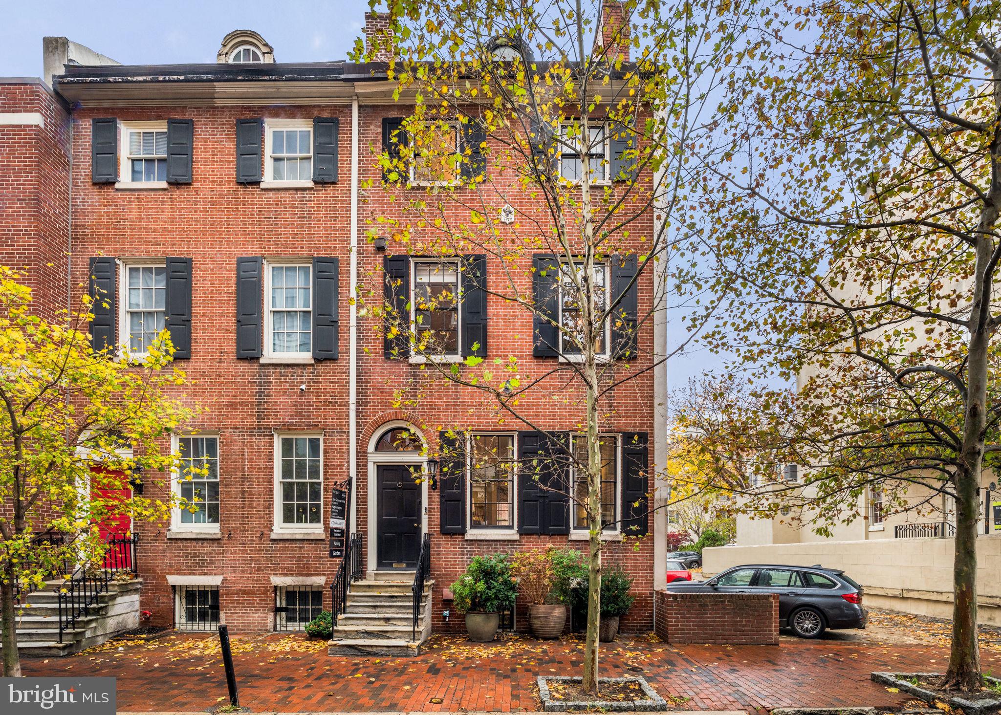 Majestically positioned on the corner of S 9th & Bonaparte Court, this 20-foot-wide Philadelphia Federal townhome, dating back to 1817, has been tastefully updated to blend historic charm with modern convenience. The home’s entrance vestibule opens through elegant double glass doors into spacious living and dining rooms, each anchored by beautiful fireplaces featuring hand-carved mantels crafted from prized King of Prussia blue marble. There are six (6) total fireplaces throughout.
The esteemed Philadelphia architectural firm Voith & Mactavish oversaw the thoughtful restoration, preserving the home’s period pine floors, plaster walls, fireplace mantels, and intricate millwork, ensuring a timeless, refined elegance throughout. Just steps away, a light-filled chef’s kitchen awaits, equipped with Leicht cabinetry, Subzero, Miele, Bosch appliances and a wine cellar. The front and back windows bathe the interior with natural light and has a rear door to your garden for snipping fresh herbs. The center hall also leads you through to a 2nd door leading to the large garden which has been meticulously designed and manicured. The garden area is private and perfect for entertaining family and friends or just relaxing while reading a book.
Again, the gracious center hall features an elegant, winding staircase leading to the upper floors. The second floor is dedicated to a serene primary suite with ten-foot ceilings, a spacious bedroom, large walk-in closet and an ensuite Carrara marble bathroom. The third-floor houses two additional bedrooms, a full bathroom, and a laundry area with Miele washer and dryer. The top floor, currently used as an office and library, offers the potential to become a charming fourth bedroom, with room to add an additional bath.
This residence includes a 1-car garage parking spot (HOA $125/month) and an optional 2nd car parking space, adjoining the house ($380/mo.) Located near public transportation, Philadelphia’s historic district, Washington Square Park, and within walking distance to top schools, dining, and shopping, this home perfectly balances luxury, history, and convenience. Your search ends here—schedule a showing today to experience this exceptional property in person!