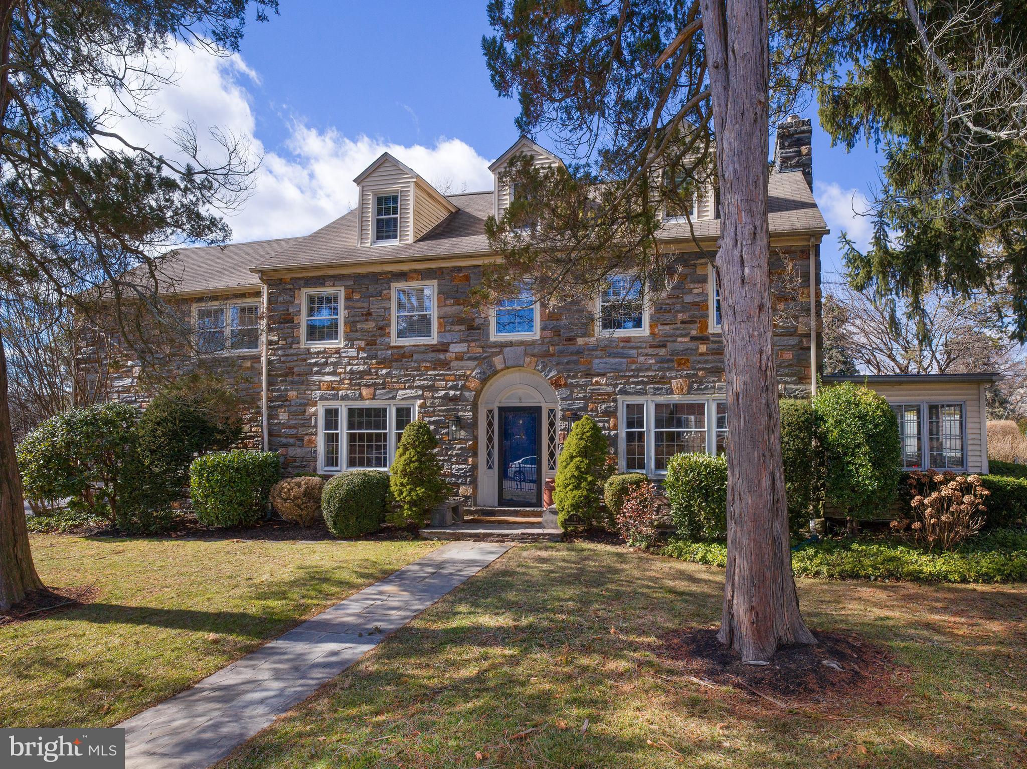 Discover the perfect blend of timeless charm and modern living in this stunning center hall stone colonial. Boasting six bedrooms and 4.5 baths, this home welcomes you with a grand foyer featuring elegant archways and wainscoting. The spacious living room, complete with a gas fireplace, is ideal for gathering with family and friends, while the beautifully renovated four-season sunroom offers a bright and tranquil retreat. A formal dining room flows seamlessly into the updated eat-in kitchen, which features custom cabinetry, premium countertops, stainless steel appliances, dual ovens, and a large pantry. The first floor also includes a powder room and plenty of closet space.
The second floor offers a luxurious primary suite with two large closets, an ensuite bath, and a private deck. Three additional generously sized bedrooms, including one with its own ensuite bathroom, provide ample space for family or guests. A hall bathroom and a convenient laundry room complete this level. The third floor adds even more versatility with two additional bedrooms, a flexible space perfect for an office or playroom, and a full hall bathroom.
Outside, the home features a large, fully fenced yard with an automatic gate, two driveways, and an attached two-car garage. A spacious covered patio with an awning is the perfect setting for outdoor entertaining. Ideally located just blocks from restaurants, coffee shops, boutiques, a farmer’s market, and the R-5 train line to the city, this home offers unmatched convenience. With low taxes and a perfect blend of character and modern updates, this property is a rare find.
