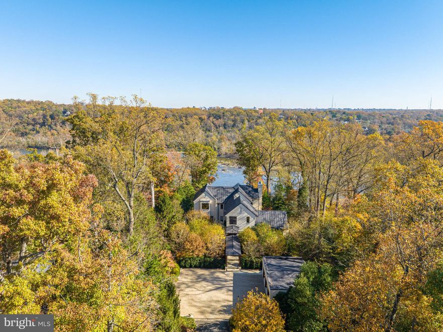 Nestled beneath a canopy of towering trees along McLean’s exclusive Gold Coast , an unassuming drive presents an extraordinary Potomac River Estate located at 1169 Crest Lane. Masterfully designed and meticulously built in 2013, this remarkable Waterfront respite sits on a 2.32-acre expanse encompassed by pristine landscaping and overlooking sweeping vistas and Moon views of the Potomac River’s rippling waters. Inside, the bespoke masterpiece displays an artfully executed floor plan centered around the everlasting beauty of nature’s landscape with walls of windows lining the striking 10,150 square foot home’s gracious entertaining salons and decadent private suites.  Designed for entertaining, the property showcases an artistic display of agelessly modern architecture juxtaposed by the organic and bountiful scenery of the 3 level estate’s surroundings, this 4 Bedroom, 5 Full Bathroom, 1 Half Bathroom architectural anomaly will certainly take your breath away.