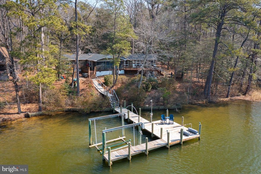 Set on nearly 1.5 acres along Cod Creek off the Little Wicomico River, this property offers an inviting waterfront lifestyle with a private dock, boat lift accommodating 3–4' MLW, and access to a golf cart–friendly community featuring a boat ramp and swimming pool. The home—topped with a new roof in 2025—provides comfortable one-level living across more than 1,600 square feet. A spacious living room with exposed beams, a wood stove, and LVP flooring opens to a private waterside deck. The updated kitchen includes stainless steel appliances, a versatile dining or sitting area, and a laundry closet. Both the kitchen and the separate dining room flow seamlessly onto a screened porch overlooking the water.
Three bedrooms include a pair connected by a Jack-and-Jill half bath, complemented by a full hall bath. Additional features include a walk-out basement and an oversized two-car attached garage. With quick boat access to the Chesapeake Bay and a location convenient to Reedville, Burgess, Heathsville, and a scenic drive to the charming town of Kilmarnock, this property blends privacy with proximity. The acreage includes three waterfront lots plus one off-water lot, offering flexibility and room to enjoy the setting.
