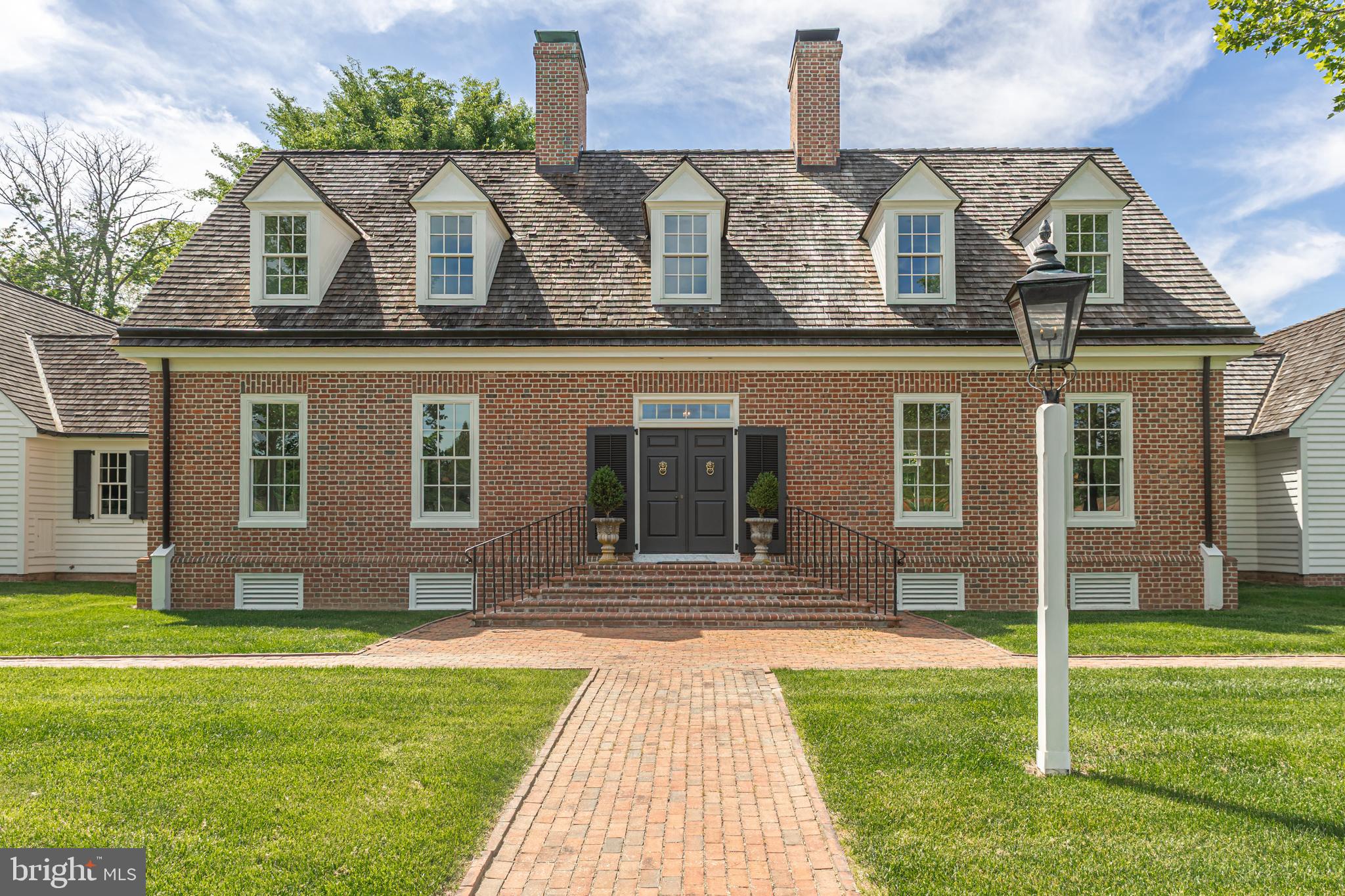 Perfectly situated on over 15 serene acres just a few hundred yards from the iconic Van Sandt Covered Bridge, is a distinguished Williamsburg-style brick estate and gentleman’s farm that seamlessly blends classic elegance with equestrian functionality. Built by renowned local master builder Jarrett-Vaughn, this custom home offers exceptional privacy, breathtaking views from every room, and unparalleled craftsmanship throughout. Once inside the double entry door, the stately main residence showcases a grand foyer with rich oak hardwood floors throughout. To the left, a formal dining room with charming built-in corner cabinets; to the right, an expansive light-filled, family room anchored by a striking fireplace Adding to the charm on the first floor is a library with a wall of buit-in bookshelves and a partial brick floor. The first-floor primary suite is a private sanctuary with dual walk-in closets, a spa-like bath with jetted tub, and sweeping views of the rear picturesque grounds. A chef’s dream, the gourmet kitchen is outfitted with Wolf and Sub-Zero appliances, granite countertops, and a large center island with farmhouse sink. Adjoing the kitchen area is sun-filled breakfast area complete with a fireplace, and French doors that open to a covered patio. Nearby are a butler’s pantry and convenient first-floor laundry room. Upstairs, you'll find two generously sized bedrooms—each with walk-in closets and en suite baths—as well as a handsome office/library with built-ins and a large balcony overlooking the gardens and a beautiful pineapple water fountain. The finished lower level is ideal for entertaining, offering a custom granite-topped bar, a cedar closet, ample finished and unfinished storage, and direct access to the oversized three-car garage. The home’s interior excellence is matched only by its meticulously designed outdoor spaces—with expansive bluestone patios perfect for outdoor entaining or just relaxing, a formal fenced in garden, and brick walkways adorned with flowering shrubs. The property includes a beautifully appointed horse facility featuring a well-designed barn with three spacious stalls, a wash stall, tack room, and abundant storage for feed, equipment, and large vehicles. Three fenced paddocks—each with direct stall access—provide the ideal setting for equestrian living. Located in prestigious Solebury Township, this property enjoys a prime location on one of the area’s most sought-after country roads. Whether you're enjoying the quiet solitude of the land, entertaining on a grand scale, or pursuing outdoor and equestrian hobbies, this property delivers it all, with timeless grace and style. Schedule your private tour today!