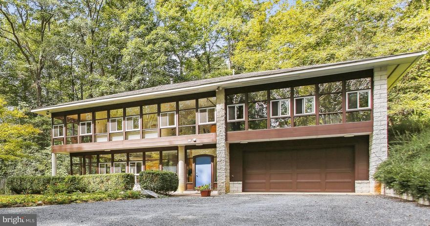 Dream House in the Woods! Unique, contemporary built by noted American designer Peter Danko, an inventor, designer and artist, whose work has been curated by and is in the permanent collection of several museums including Museum of Modern Art, Cooper Hewitt Museum, Smithsonian American Art Museum and the Museum of Fine Arts in Boston. 
The house is earth-sheltered, designed with passive solar energy features, including glass on two sides with wall to ceiling views framed with mahogany, bathing the house in natural light.  A seamless addition was added in 2006 that includes an attached two car garage, additional bedroom and an exercise/family room with a private sauna.  Features include 10 ft ceilings on first floor and custom finishes. 
The house is located in the Moyaone Reserve, contiguous to Piscataway Park, home of the National Colonial Farm, and Hard Bargain Farm, an environmental education center, and is across the Potomac River from George Washington’s Mount Vernon home.  Miles of hiking and biking trails, kayak and canoe launch sites are close by. Established community includes access to swimming pool, playground and organic garden plot. Within an easy commute to downtown DC, National Harbor, Old Town Alexandria and Capital Hill.