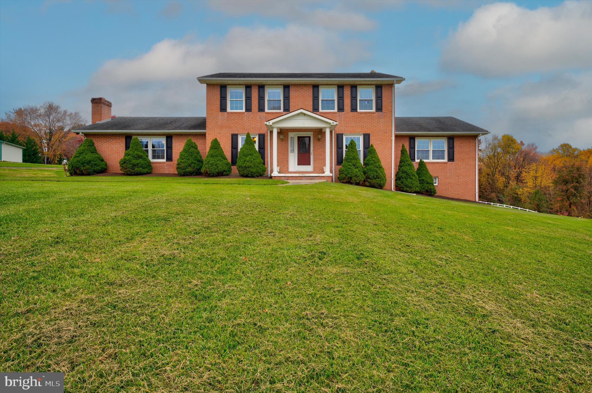 This all brick 5 bedroom colonial on a picturesque 3.66 acre lot offers 2,880 sq. ft. of living space. Full unfinished basement could be finished to your taste. Kitchen with plenty of cabinets. Family room with wood burning fireplace. Formal living room. Primary bedroom with his and her bathrooms. Large enclosed porch with screens and sliding glass doors in rear to enjoy the outdoors. 40' x 60' building with oversized garage door, toilet room and propane heat. Attached side building with rear garage door that could be used for storage or stables (buyer must verify).