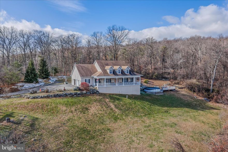 Welcome to The Million Dollar View—a custom-built 2006 Cape Cod retreat perched on 12 private acres atop the mountain in Frederick County, Maryland. This stunning 4-bedroom (with a main-level primary suite), 4.5-bath home offers over 5,130 sq. ft. of finished living space, breathtaking sunrise and sunset views, and exceptional craftsmanship throughout. Built with meticulous care by the owner, this residence showcases quality upgrades, spacious rooms, and endless potential both inside and out. No HOA and no restrictions. Inside, the main level features a grand two-story foyer with a beautiful staircase, a formal dining room, a private office with a closet, and a spacious living room centered around a wood-burning fireplace. The luxury kitchen boasts abundant cabinetry, a double oven, generous counter space, and gorgeous views from every window.  The main-level primary suite includes tray ceilings, abundant natural light, a large walk-in closet, dual vanities, a soaking tub, and a separate shower.  Upstairs, you’ll find three additional bedrooms and two full bathrooms—one being a convenient Jack-and-Jill layout—plus excellent storage throughout. The fully finished lower level offers outstanding versatility with a custom bar, full bathroom, gym/workshop space, large storage rooms, and the potential to create two additional bedrooms or an in-law style suite.  Outdoor amenities include an above-ground pool with vinyl decking and railings, a wide front porch overlooking panoramic mountain views, a three-car attached garage, a poured foundation ready for a future detached garage, an outbuilding for wood/storage, dual-zone heat pumps, and Verizon high-speed internet. You’ll also love the custom-built outdoor grill—perfect for summer entertaining.  This property is ideally located near Cunningham Falls State Park, High Rock, Thurmont Community Park, local restaurants, and major commuter routes. High Rock is one of the area’s most popular scenic hiking destinations, making this home a paradise for nature lovers and outdoor enthusiasts.  Seller will need a home-of-choice contingency. Don’t miss this rare opportunity to own a custom-built mountain-top estate offering unmatched views, privacy, and spectacular potential.