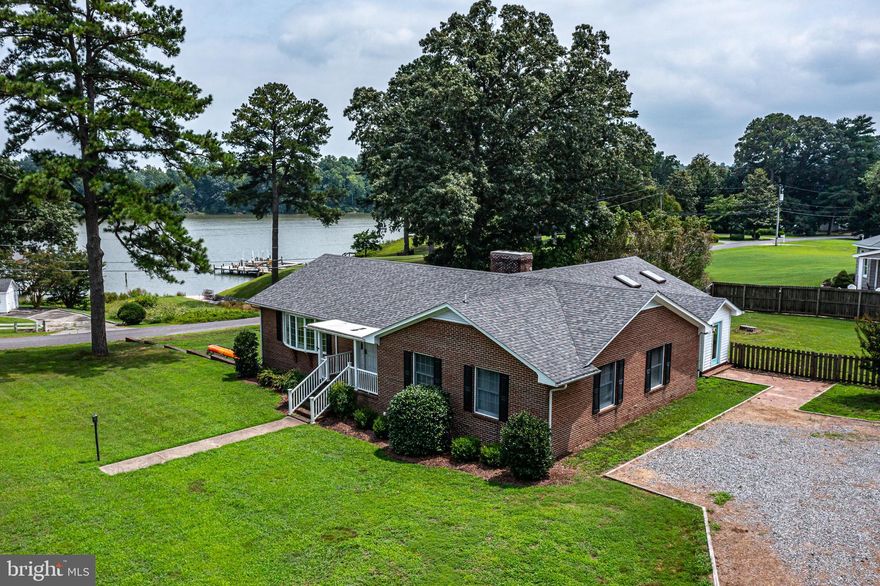 Stunning updated coastal style home with INCREDIBLE WATERFRONT VIEWS of popular Urbanna Creek!   Rarely available "in-town" location makes it easy to walk, bike or golf cart to the charming shops, restaurants and marinas in historic Urbanna - a popular boating/sailing destination and home of the famous Urbanna Oyster Festival.  Deeded water access and private boat ramp directly across from the oversized deck provide all the benefits of true waterfront living without any of the maintenance or cost! Put your boat, water toys or your kayaks into one of the Middle Peninsula's favorite waterways or just sit on the expansive waterside deck and enjoy the AMAZING WATER VIEWS.  This spacious home has undergone and extensive renovation throughout including a gorgeous kitchen update (2019) with beautiful white cabinets, luxury laminate wood floors, top-of-the line stainless steel appliances, and quartz countertops.  A wood-burning fireplace off the kitchen makes for the coziest spot in the house! Both bathrooms have also been masterfully updated (2021 and 2022) with new tile flooring, floor-to-ceiling tile in showers, new vanities and new fixtures.  Along with 3 private, oversized bedrooms, you'll find two great gathering spots on the main level.  A large living room with oversized bay window offers a quiet respite after a long day on the water, and a light-filled creekside great room provides space for everyone, great views to the water and glass patio doors to the fantastic deck.  Rare full basement has a second large laundry room with utility sink, a partially finished rec room area with wood-burning fireplace and a HUGE workshop and storage room with a 2-piece plumbing rough-in. Basement walls and flooring freshly paited.  The oversized two-car garage is deep enough to store your boat and water toys and opens into the basement from the water-side for quick access and  convenient clean-up.  The timeless brick exterior features a charming front porch and mature landscaping. Outdoor living is easy with  the extra large, modern waterside deck with cable rails - perfect for entertaining or just watching the sunrise - a fire pit area overlooking the creek, a fenced back-yard (2019), garden shed and a huge stone driveway.  Recent updates also include a NEW ROOF (2025) and New Main Level HVAC (2024). This low maintenance property in the popular Garnett Hill neighborhood, is the perfect weekend getaway or short-term rental property (STR history available upon request) and is just 60 minutes to Richmond and 2.5 hours to the DC Metro area. Furniture, jet skis, jon boat and golf cart all available for sale separately to make this a truly turnkey home!  BRING YOUR BEACHTOWEL AND SUNSCREEN AND GET READY FOR A SUMMER TO REMEMBER. Don't wait to see this home!