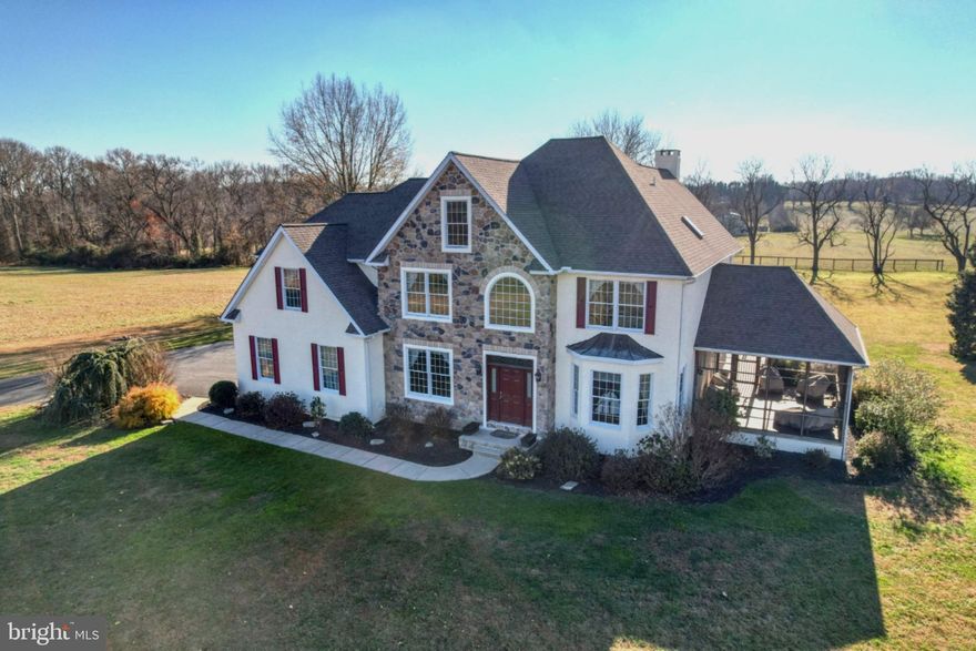 Escape to your own 16+ acre sanctuary where sweeping water views of the northern Chesapeake Bay and unforgettable sunsets are everyday living. Set in a unique community on the Bohemia River, this custom-built home is a true reflection of thoughtful design, meticulous care, and genuine pride of ownership. Tucked within a quiet, close-knit community of just 29 residences, this home was designed with careful attention given to every detail, from the layout and finishes to how the home captures natural light. Enhanced by private, groomed walking and riding trails that wind through the wooded surroundings and a park-like setting with a gazebo, it offers the perfect blend of refined living and outdoor freedom. The property also allows for up to two horses, a rare opportunity in a private community, lending itself to an elevated equestrian lifestyle. A welcoming 2-story foyer with ceramic tiles opens to gleaming hardwood floors that flow through the living room, dining room, and family room, where classic crown molding, chair rail, recessed lighting, and an abundance of windows create a warm atmosphere. The heart of the home is the large family room, anchored by a beautiful stone wood-burning fireplace and overlooking the surrounding acreage, while French doors lead to a screened porch with ceramic tile and recessed lighting - an ideal place to unwind and take in the peaceful views connecting to a wraparound deck also accessible from the breakfast room. The kitchen is functional and inviting, boasting granite countertops, cherry cabinetry, tile backsplash and ceramic flooring. Additional features include a walk-in pantry, double wall ovens, island prep sink, and spacious breakfast bar. A powder room is tucked just off the foyer. Upstairs, hardwood stairs and hallways lead to an expansive primary suite with a deep tray ceiling, hardwood floors, recessed lighting, windows on multiple sides, an en-suite bath with jetted tub, separate shower and water closet as well as an expansive walk-in closet. Three additional well-sized bedrooms, full bath, and large second-floor laundry room with utility sink provide everyday convenience. The full basement spans the entire footprint of the home and is accessible through the two-car turned garage, which also includes a powder room. Complementing the main residence is a versatile secondary structure featuring a well-equipped workshop with built-in dust collection and HEPA air filtration, ideal for woodworking, creative pursuits, or serious hobbies along with a barn-style storage area that includes additional storage. Perfectly poised for equestrian use, this building can easily be converted into a barn, or a new facility can be built for avid horse lovers. The property is vast and private, bordered by mature trees, woods, and water access. Outdoor enthusiasts will appreciate the landscape alive with natural beauty, including deer and bald eagles. Boating, fishing, and quiet exploration are all part of everyday life here. Horse enthusiasts can enjoy private trails right on the property itself with even more riding opportunities just minutes away, including Bohemia River State Park and Fair Hill Natural Resources Area, known for their expansive trails on thousands of scenic acres. This home has been exceptionally well cared for and is truly move-in ready, supported by a substantial recent investment of over $60K in professionally completed stucco remediation and exterior improvements, undertaken proactively to enhance longevity and peace of mind. Despite its peaceful, tucked-away setting, the property is well-connected with high-speed fiber optic internet and offers convenient access to Philadelphia, Baltimore, and private or regional air travel. Just minutes from Middletown, Delaware and Chesapeake City, you'll find wineries, shopping, and waterfront dining just a short drive away. Don't miss this rare opportunity to own a lovingly built and impeccably maintained Chesapeake Bay retreat.