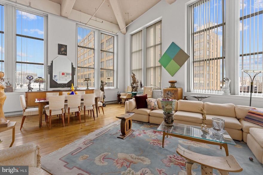 Welcome to the historic Beaux Art Loft Building located at 1238 Callowhill Street in the loft district of Philadelphia with quick and easy access to the highline and a short stroll to Chinatown and CC.
This is a once in a lifetime opportunity to obtain not 1, but "2" penthouse units. This spectacular unit spans the entire north side of the building and then down along the west side 2 window bays.... providing great views of the newly finished highline and great sunsets in addition the incredible northern light. Windows that reach 11' in height and ceilings that tower 18' with concrete, hardwood floors throughout, with marble and tiled baths and stone accents.
The main kitchen had granite counters and stainless-steel appliances.  This home was crafted to create a unique one-of-a-kind space. The current owner carefully blended 2 units together to create a home featuring a sumptuous, 850-sf primary suite with a sitting area, full bath and a walk-in closet. Down the hall into what was another unit totaling 1200 sf is now the oversized living room with wood burning fireplace, kitchen, a 2nd bath and the perfectly placed dining room for those sunset dinners. There are 2 zones of heat and air.  The building has just replaced the roof and created wonderful roof deck with multiple areas for lounging and dining.
Lofts this special don't come along often, so please come a take a tour.