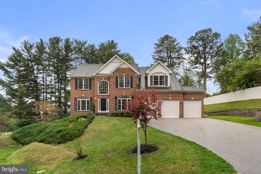 Set within one of Ellicott City’s most sought-after enclaves, this distinguished Colonial residence
presents a refined interpretation of luxury living, where timeless architecture meets a thoughtfully
curated, open-concept design. Expansive interiors are bathed in natural light and enhanced by graceful
columns, intricate crown molding, and elevated finishes that create a sense of quiet sophistication
throughout.
Rich hardwood flooring unfolds across the main level, beginning with a dramatic two-story foyer that
sets an elegant tone. The formal dining room is framed by architectural columns and elevated by a
contemporary built-in china display and bespoke wood-paneled accent walls, offering a striking setting
for memorable gatherings. Opposite, the formal living room, adorned with arched windows and refined
detailing, provides an intimate space for conversation and entertaining. At the heart of the home, the
grand two-story family room captivates with soaring ceilings, a gas fireplace, and a wall of upper arched
windows that fill the space with soft, natural light.
The gourmet kitchen is seamlessly integrated for both daily living and elevated hosting, featuring a
well-appointed butler’s pantry, custom cabinetry with glass-front accents, a generous center island,
stainless steel appliances, and a walk-in pantry. The adjoining breakfast area, with direct access to the
outdoors, enhances the home’s effortless flow. A private main-level bedroom suite with its own bath
offers ideal accommodations for guests or multigenerational living, complemented by a conveniently
located laundry room.
Upstairs, four spacious bedrooms and three full baths provide a balanced blend of comfort and privacy.
The primary suite is a true retreat, defined by cathedral ceilings, a serene sitting area, and a
custom-designed walk-in closet. The spa-inspired bath features a corner soaking tub, a separate
glass-enclosed shower, dual vanities, and a private water closet. Two secondary bedrooms share a
thoughtfully designed dual-entry bath, while an additional bedroom enjoys its own en-suite.
The walk-out lower level extends the home’s living space with a generous recreation area, a sixth
bedroom with a walk-in closet, a full bath, and versatile unfinished areas—including a dedicated space
with gym flooring, ideal for a private fitness studio or future customization.
Outdoors, the property unfolds into a beautifully landscaped setting designed for both relaxation and
entertaining. A custom paver patio with a curved retaining wall overlooks a spacious, level backyard
framed by mature pine trees, offering privacy and a tranquil backdrop. Multiple terraced areas provide
exceptional potential for a future pool, outdoor lounge, or play space, completing this exceptional
offering.
