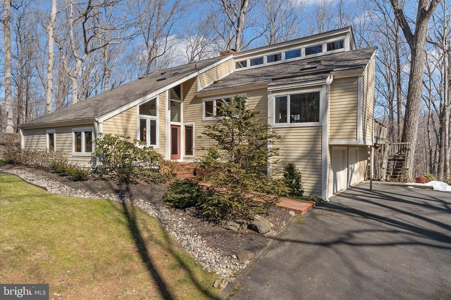 Nestled within an exclusive enclave of just 8 homes, this stunning contemporary retreat sits on over 5 acres of serene, wooded privacy — less than a minute from the charming, historic town of Clifton, one of Northern Virginia's most treasured destinations and a proud member of the National Register of Historic Places. This is a rare one-owner home — lovingly cared for, thoughtfully maintained, and cherished every single day since it was first built. The sellers will be the first to tell you this home has been a true joy to live in, and while they're excited about the next chapter, let's just say the goodbye won't be easy. For the lucky buyers who get to call it home next, that devotion shows in every detail — from the brand new HVAC (2025) and roof (2021) to the Pella vinyl-clad windows, updated kitchen (2019), LVP flooring in the kitchen and breakfast room (2022), new electric water heater (2023), LG washer and dryer (2024) and professionally maintained landscaping with newly updated split-rail fencing (2024). Thoughtfully designed across five distinct levels, the home opens at ground level to the main bedroom wing. Four generous bedrooms, each with ample closet space, including one that doubles as a serene sitting room with direct walk-out access to the tranquil koi pond tucked along the side of the house. A Jack & Jill bath serves this level beautifully. One level up, the heart of the home unfolds. The updated kitchen sits at the front of the house, bathed in natural light from skylights and Pella windows overlooking the lush front yard.  LVP flooring is underfoot and a charming breakfast nook features custom cabinetry that perfectly matches the kitchen — and conveys with the home. The expansive family room and dining area feature soaring vaulted ceilings with rich tongue-and-groove wood planking and exposed beams, and three sliding doors opening to the spectacular 16x32 deck — complete with stairs descending to a lower deck and the driveway below.  The fourth level is devoted entirely to the primary suite — a peaceful sanctuary with a vaulted wood ceiling, generous dressing area, full bath, and stunning picture windows that pour in natural light from every angle. At the top, a dramatic loft-style level overlooks the living and dining areas below, with two additional storage areas — ideal as a home office, creative studio, or reading loft. The lower levels provide exceptional utility: a 2-car garage, an impressive 16x24 workshop, and a dedicated laundry room. A bridle path runs along the bottom of the lot, and a charming shed nestled in the trees completes this one-of-a-kind property. One family's paradise is about to become yours.