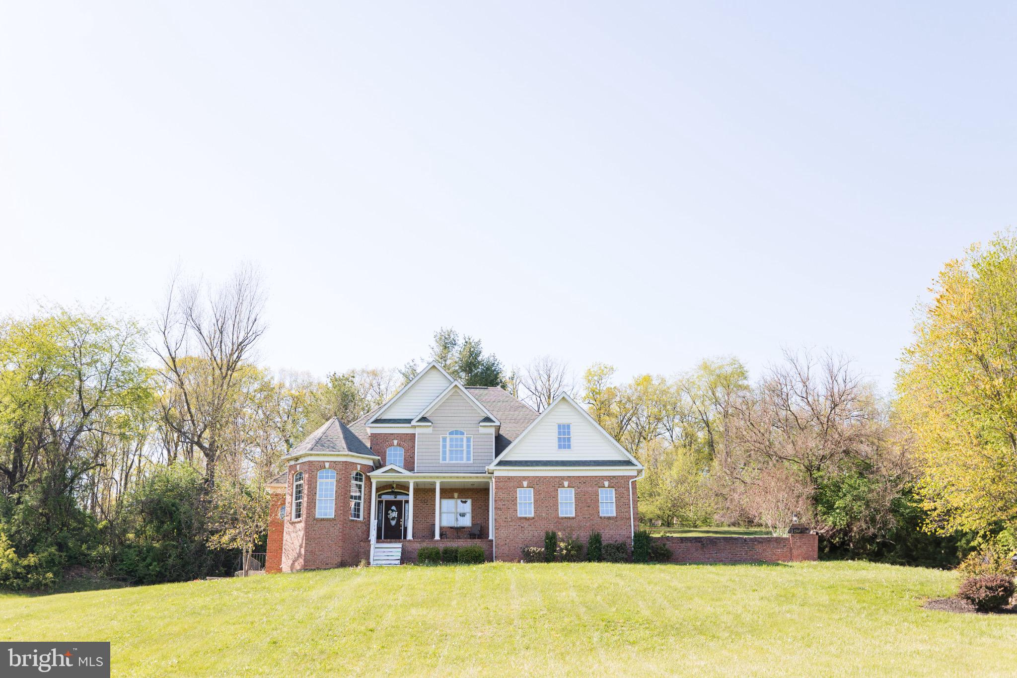 This charming Colonial-style home, built in 2008, offers a perfect blend of comfort and elegance, nestled on a generous 4.08-acre lot. As you step inside, you'll be greeted by a warm and inviting atmosphere, highlighted by beautiful hardwood floors and plush carpeting throughout. The spacious living area features a stunning stone fireplace, creating a cozy focal point for gatherings. The heart of the home is the well-appointed kitchen, equipped with modern appliances including a dishwasher, microwave, and electric range, making meal preparation a delight. The formal dining room is perfect for entertaining, while the entry-level bedroom provides convenience and flexibility. Retreat to the primary suite, complete with a luxurious en-suite bath and a walk-in closet, ensuring ample storage. Step outside to enjoy the serene surroundings, featuring a lovely patio and tranquil water fountain, ideal for relaxation. The attached side-entry garage offers easy access and additional storage space. With a full unfinished basement ready for your personal touch, this home is a canvas for your dreams. Experience the perfect blend of modern living and natural beauty in this exceptional property, where every detail has been crafted for comfort and style. Don't miss the opportunity to make this house your home!