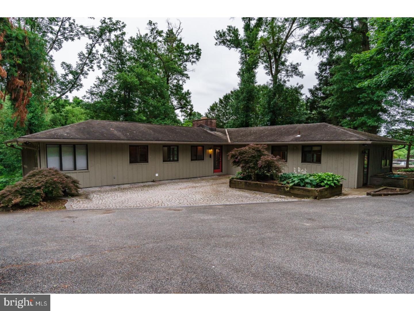 This mid-century contemporary sits on almost 3 acres, back off the road at the top of a creek valley.  The driveway winds its way up the hill to an outdoor parking area and detached garage.  One enters the house into a large open living room/dining room area, with cathedral ceilings and a wood burning fireplace.  The back of the house is mostly glass looking back out over the green valley.  On one end is the master bedroom, with loads of closet space and full bath, and on the other, the kitchen with lots of light, space and newer appliances.  This end of the house opens to a large deck and a wonderful gazebo, beyond which is an inground pool with a stunning view.  Downstairs are a family room with outside entrance, bedroom and small office or 3rd bedroom.  This level of the main house has its own kitchen and could be readily converted to an in-law suite.  The house also has an attached apartment with its own bedroom, living room and kitchen.  The garage is oversized, with a rear storage area and attached large open space ? ideal for a workshop, detached office or more storage space.  The property is being sold "As Is" and the Seller's Disclosure includes a recent Home Inspection report.   The house needs some TLC, but is very livable and would make an extraordinary home.  The location is just north of Route 1 in between Route 202 and the Brandywine River.  Within easy commuting distance to West Chester, Kennett Square, Philadelphia, Wilmington and beyond.