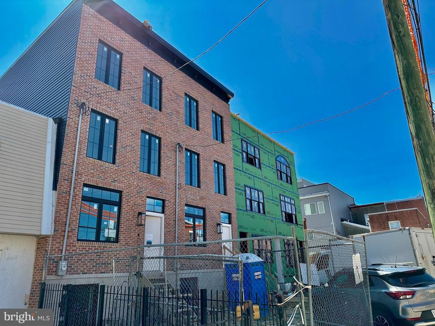 ** Ask for VIDEO TOUR and professional PHOTOS ** Welcome to your thoughtfully crafted new construction home in Fishtown’s Adaire catchment. 1 YEAR WARRANTY included. Ask about the 10-YEAR TAX ABATEMENT! This spacious home sits on a deep lot along a quiet side street, offering 3 bedrooms, 3 full bathrooms, and two bonus rooms—perfect for guest accommodations, an office, or a gym. The design blends classic Philadelphia charm with modern elements, featuring premium earthy finishes. Among its contemporary amenities are expanded driveway parking (pre-wired for EV charging), multiple private outdoor spaces, and ample storage.This location is prime for you to enjoy everything Fishtown has to offer. Explore a variety of restaurants, bars, shops, cafes along Frankford and Girard Avenue. The waterfront is just a quick walk away, providing more parks and entertainment options. You’ll also find a wealth of dining and entertainment in Northern Liberties and Old Kensington nearby. Less than a block’s walk is Adaire Elementary School, along with the Fishtown Recreation Center, Community Library, and Lederer Pool. Plus, you’re close to Fishtown Montessori School, PlayArts, and a sprayground. For easy commuting, you have quick access to Highway 95, the Ben Franklin and Betsy Ross Bridges, Philadelphia International Airport, and the Market-Frankford Blue Line, which connects you to Old City, Center City, and other areas. Complementing this desirable location are the classic exterior features of the home including a red brick facade and black double casement French windows beneath a stylish black cornice. An elevated front entrance enhances privacy for the main living level. Inside wide plank French oak floors spread across an open layout connecting the living and dining areas to the gourmet kitchen. Desirable natural light consumes the entire home from the front and rear. Soft recessed lighting and curated fixtures throughout offer versatile options, from bright and functional to warm and ambient. For added efficiency, this home is furnished with two HVAC systems. Designed for both functionality and aesthetics, the kitchen features GE Café appliances, a 36” professional gas range, and quartz countertops with matching backsplash. Mounted over the oven is a custom 42” hood flanked by soft lighting sconces and a long spice shelf. The kitchen island offers a deep sink and a place to sit or prep. Ample cabinetry, including three built-in pantries and a closet with opaque glass doors, ensures optimal storage. Through the sliding doors, the spacious deck is perfect for outdoor dining and comes equipped with a gas line for grilling. A grassy area off the deck can be used for pets, a small garden and/or entertaining. The finished basement provides additional living and storage space including two separate rooms each with their own closets and egress. In the hall, a full bathroom is finished with an Italian tile walk-in shower and oak vanity. Leading upstairs, the floating oak staircase is well-lit by recessed tread lights. There are two bedrooms on this floor, including a walk-in closet in the front room. All bedrooms above grade have generous windows allowing in plenty of natural light. The hall features a full bath finished with Italian tile, a deep-set tub and shower, textured porcelain floors, and an oak vanity. Additional features include a built-in laundry closet and a separate linen closet. On the third floor, the primary suite showcases opaque French glass doors leading through the custom organized closet into a spa-like bathroom. Double doors open to an oversized 71” soaking tub against a full wall of Italian tile. The bathroom also features a tiled walk-in shower with bench, separate toilet room, double sink vanity, and a linen closet. Enjoy stunning unobstructed views of the Philadelphia skyline from your spacious roof deck. Buyers are responsible for verifying taxes and square footage.