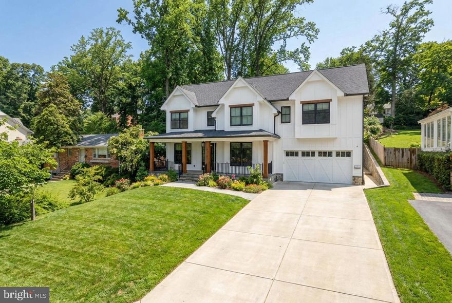 An exceptional custom residence, 6027 Walhonding Road presents a rare opportunity to experience refined living in Bethesda’s coveted Glen Echo Heights neighborhood. Set on a generous lot, this remarkable home spans more than 5,500 square feet of thoughtfully designed space, where timeless craftsmanship and modern sophistication come together in perfect balance. From the moment you enter, the main level sets an impressive tone with crown moldings, gleaming floors, and expansive windows that fill the home with natural light. . A welcoming foyer introduces elegant living and dining rooms on either side, offering beautifully proportioned spaces for both everyday living and formal gatherings. Just beyond, the great room unfolds as the centerpiece of the home, anchored by a striking fireplace and framed by walls of glass that open seamlessly to the screened porch. With its own built-in fireplace and views across the patio and expansive backyard, this space creates an inviting setting for entertaining in every season. The signature kitchen serves as the heart of the home, designed to inspire both casual meals and elevated culinary moments. Quartz countertops, sleek modern cabinetry, and premium appliances create a sophisticated workspace, while the generous island offers comfortable seating and a natural gathering place for family and guests.

Upstairs, the primary suite provides a peaceful sanctuary further bathed in natural light. Spacious walk-in closets and a spa-inspired bath finished with marble tile, a freestanding soaking tub, a glass-enclosed shower, and dual vanities deliver a luxurious retreat designed for comfort and relaxation. The lower level continues the home’s generous scale with a large recreation room, exercise room, along with a versatile sixth bedroom and full bath, ideal for guests, extended family, or flexible living needs. Outdoor living is equally captivating at 6027 Walhonding Road. A welcoming front porch overlooks leafy treetops, while the screened rear porch and multi-tiered backyard create a serene setting that blends privacy, nature, space, and elegant design just moments from the shops, dining, and conveniences of Bethesda.