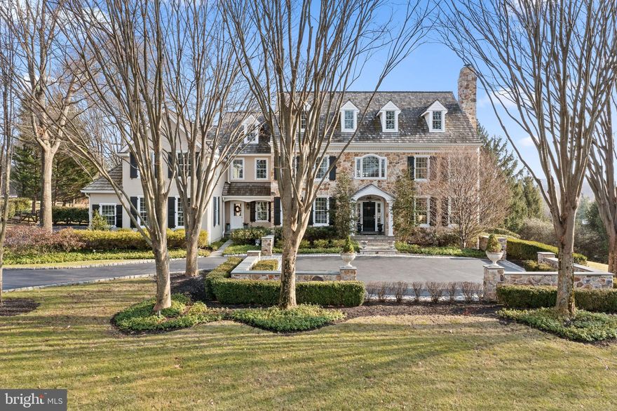 Listing agent must accompany all showings. A tree-lined drive leads you to a stately stone-and-stucco residence on an impressive corner lot surrounded by expansive, lush green lawns. Come home to The Harrison Estate, among the most sought-after neighborhoods in historic Newtown Square. A Hastings II floor plan, this spectacular traditional center-hall home by award-winning builder Tom Bentley offers nearly 7,500 square feet of beautifully designed and carefully crafted living spaces, w/ 5 bedrooms, 4 full and 3 half baths, a finished lower level and an in-ground pool and oversized flagstone patio w/ pergola all on 1.5 acres shaded by mature trees. This desirable address puts you in the Marple-Newtown School District, close to several of the Main Line’s finest private schools, convenient to Route 30 and the Blue Route, and just 2 miles from downtown Wayne and the Wayne train station w/ commuter service to Philadelphia.
Built in 1997 as one of the neighborhood’s original models, this gorgeous home features upgrades throughout, including new windows, all new stucco and newer cedar roof, hardwood floors and French doors, plantation shutters,  high-quality details like curved archways, crown molding, built-ins and other extensive woodwork. The property has been continually updated, w/ renovations inside and out, for style and comfort.
With black-and-white marble and hardwood flooring, the front-to-back center hall makes a grand impression. Off the foyer to the left are an elegant formal dining room and butler’s pantry w/ wet bar. To the right, a black marble fireplace provides a focal point in the living room, which offers access to an office accented w/ warm wood paneling and a wall of bookshelves.
Follow the center hall past the guest powder room and the stairwell, beneath the balcony, to a light-filled sunroom w/ expansive windows and slatted wood ceiling. Through the French doors, a gorgeous outdoor living space awaits, w/ a recently renovated pool/spa, built-in grill and more for family fun and entertaining.
Beyond the butler’s pantry, the spacious chef’s kitchen is a gourmet’s delight, featuring a center island w/ seating for 4 and premium appliances. The breakfast room also offers access to the patio through French doors, as does the adjacent family room. A generous space w/ multiple seating areas, a vaulted ceiling, stone fireplace and built-in cabinets and bookshelves, it’s the perfect place to relax w/ family and friends. Nearby is a convenient 2nd powder room and a mudroom with a built-in desk, an outside entrance, a back stairway to the upper level and access to the attached 4-car garage.
The upper level combines light-filled rooms and commanding views of stunning sunsets, updated spaces and an array of amenities for your comfort and convenience. The sumptuous primary suite boasts a dressing/sitting room with walk-in closets built out with shelving, plus a large and luxurious bath with double vanities, a water closet, spa shower stall and sumptuous soaking tub. Two bedrooms each feature en suite bathrooms, one with a tub. Two larger bedrooms share a completely renovated Jack-and-Jill bath. The upper level also features a laundry room w/ a utility sink and built-in shelves and counter.  An upstairs family room w/ built-in desk area is ideal for doing homework or hanging out. From this area, stairs lead to a 3rd floor that is ready to finish if desired.
Trimmed in light woods, a sunlit lower level w/ multiple full-size windows and recessed lighting provides a great space to play, w/ a glass-enclosed gym, a game room w/ space for a pool table, plus a TV/family room and a convenient lower-level powder room.
This extraordinary residence is part of an intimate community of just 54 homes on 200 rolling acres adjacent to open space protected by the Brandywine Conservancy and just a mile from the Willows Park Preserve, w/ walking trails and a full schedule of community events.