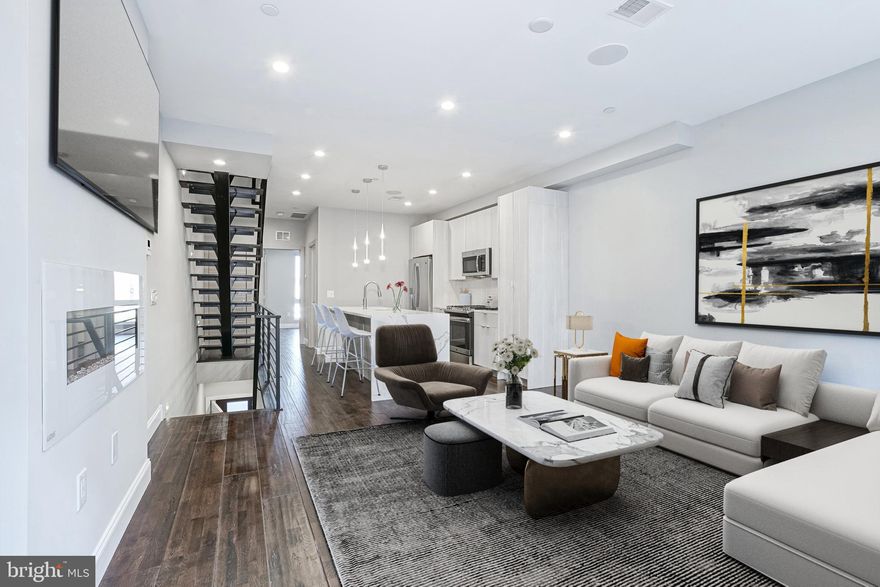 Experience elevated city living in this stunning new-construction bi-level condo, perfectly designed for modern luxury and effortless style. Every detail has been thoughtfully crafted—from the spacious open-concept layout to the exquisite finishes found throughout.  Step inside to a bright and airy main level featuring soaring ceilings, hardwood floors, and an elegant fireplace that anchors the living area. The chef-inspired kitchen is a showpiece with sleek white quartz countertops, a waterfall island, premium stainless steel appliances, and streamlined cabinetry offering abundant storage. Just off the kitchen, enjoy a charming balconette and expansive windows that flood the space with natural light. This level also includes a generous bedroom and a full bath with a spa-inspired LED mirror and rainfall shower.  Ascend the floating staircase to the upper level, where you’ll find an additional bedroom, full bath, and convenient in-unit laundry. The expansive primary suite is a true retreat, complete with two closets, a beautifully appointed ensuite featuring dual rainfall showerheads, and heated tile floors for a touch of indulgence.  
Entertain or unwind on your massive private roof deck—perfect for soaking in panoramic city views and breathtaking sunsets. Additional features include a high-end security intercom system, integrated wireless speakers, and more than four years remaining on a full 100% tax abatement.  Situated on a fully redeveloped block in the desirable Francisville neighborhood, this residence is just steps from Fairmount’s acclaimed cafés, bars, and restaurants, as well as the city’s first ALDI supermarket.  With the subway, Art Museum, Center City, and major shopping destinations all nearby, this home offers the perfect blend of luxury, location, and lifestyle.  Schedule your private showing today—your modern urban sanctuary awaits.