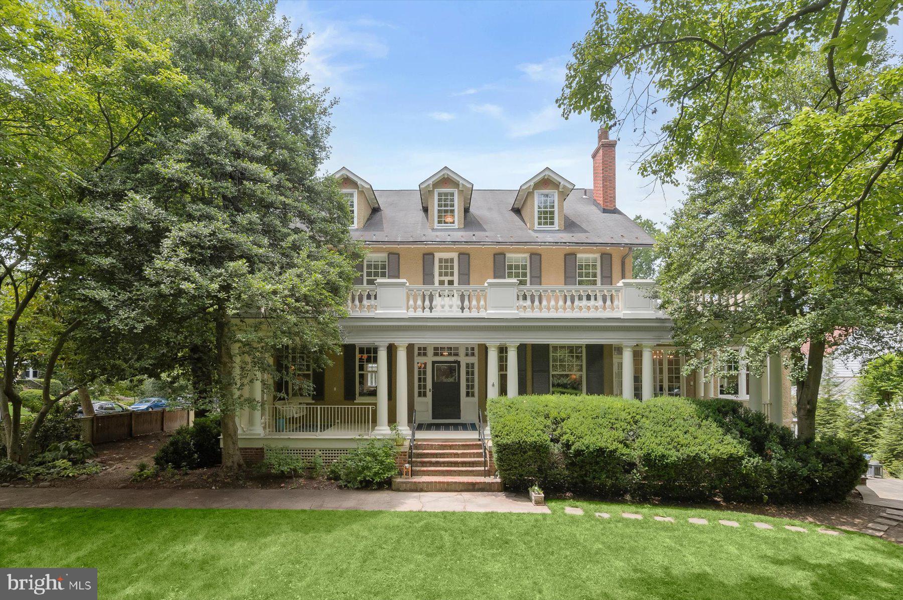 Constructed in 1908, this distinguished Colonial Revival residence stands as one of the seminal grand estates within Chevy Chase Village. Elegantly proportioned, the historic home includes a thoughtfully designed two-story addition by acclaimed architect Cliff Elmore, built by Mauck-Zantzinger. The property encompasses approximately 8,480 square feet of refined living space across four levels (per Floorplan Visuals), situated on a generous 16,667 square foot lot (per public records).
The residence boasts expansive entertaining rooms characterized by soaring ceilings and grand scale. Architectural details such as six fireplaces, hardwood flooring, double-hung windows, and glass door transoms enrich the historic ambiance throughout. Upon entering from the original colonnaded wrap-around porch, guests are welcomed into an exquisite foyer and gallery, flanked by a corner living room and formal dining room—both featuring wood-burning fireplaces and impressive bay windows.
Adjoining the foyer are a private home office, powder room, and walk-in coat closet. The gourmet kitchen, custom designed for both function and style, offers marble countertops, a substantial center island, peninsula bar seating, ample cabinetry, dual sinks, a pantry, and a built-in desk area. Top-tier appliances include a Sub-Zero refrigerator and freezer, Miele dishwasher, dual Wolfe wall ovens, and a six-burner Wolfe gas range. The kitchen seamlessly connects to the magnificent family room, which features an 11-foot, 9-inch ceiling, a wood-burning fireplace, and a distinctive glass-paned inglenook with built-in window seats. Additional amenities in this space include a breakfast area, a walk-in dry bar, a secondary staircase to the lower level, and French door access to the porch.
The stately main staircase leads to the second floor, where the expansive primary suite, formerly two rooms, has been transformed into a luxurious corner retreat. This suite includes a wood-burning fireplace, two walk-in closets, a dressing room, and dual access points to a terrace overlooking the beautifully landscaped grounds. The primary bathroom is appointed with a double vanity, walk-in shower, soaking tub, and generous storage. Two additional corner bedrooms—one with a fireplace and both with walk-in closets—are served by a renovated Jack-and-Jill bathroom featuring a double vanity and tub/shower combination.
The third level offers three additional bedrooms, ample storage, a hallway bathroom with a walk-in shower, a shared sitting area, and an attic/utility room. The finished lower level, accessible via a separate staircase, comprises a spacious recreation room, an entertainment/media room with a gas fireplace and walkout access to the flagstone patio and landscaped yard, as well as a bedroom, hallway bathroom, laundry room, and two utility rooms.
The property’s fully fenced grounds provide privacy enhanced by mature trees and shrubbery. This remarkable home, previously owned by only a select few including the prominent judge who originally commissioned it as a vacation estate, is now presented to the market with great pride.