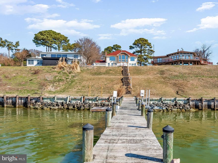 Rare opportunity to own waterfront on the Patuxent River in Calvert. Just minutes from Solomons, this home is defined by its setting and the expansive views across the water.

From the moment you enter, the river becomes the focal point. Large windows frame wide open views and bring natural light throughout the main living spaces. The view across the Patuxent extends for miles, providing a commanding waterfront setting with expansive open water vistas. Boats move steadily along the river throughout the day, and in the evening the western exposure delivers the kind of sunsets the Patuxent is known for.

The main living areas are comfortable and open with hardwood floors and a brick fireplace that anchors the space. The layout allows the living areas to take full advantage of the water views while maintaining a natural flow between the kitchen, living spaces, and the deck overlooking the river.

The home is arranged across three levels, offering space for everyday living as well as hosting guests. The upper level includes two bedrooms and two baths positioned to capture elevated views of the river. The lower level provides four additional bedrooms and two baths, creating a layout that easily accommodates extended family and visitors.

With 77 feet of waterfront on the Patuxent River, this property is built for life on the water. The private pier is equipped with multiple boat lifts and offers more than 3 feet of water depth at low tide at the end of the dock. From here, it is only a short boat ride to Solomons for waterfront restaurants and marinas, with the Chesapeake Bay just around the corner for fishing and open water access.

Located in the Drum Point community, residents also have access to a neighborhood beach on the Chesapeake Bay along with a community boat ramp. The location is also convenient to PAX River, making this a rare opportunity to enjoy true waterfront living with easy access to the area’s major employers, boating destinations, and the open waters of the Chesapeake.

Properties with open western sunsets over the water rarely become available. Do not miss the opportunity to see this one.
