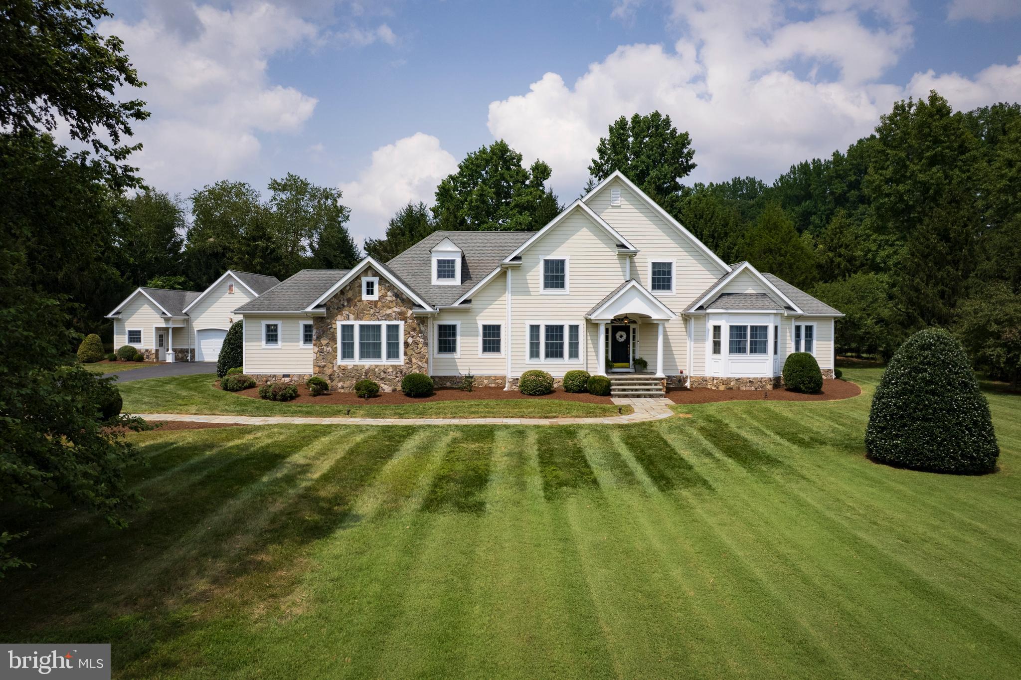 Grand Curb Appeal & Main-Level Luxury – Custom Estate on Over an Acre
From the moment you arrive, this custom home makes a statement with its grand estate entrance, striking curb appeal, and prime location—less than a minute to Route 50. The main level offers formal living and dining rooms, a spacious family room with fireplace, and a sun-filled billiard/game room. The kitchen is a true showstopper—huge, beautiful, and designed for both cooking and gathering. Sunlight pours in through generous windows, highlighting the rich custom cabinetry, center island, and handy recipe desk. An open dining area overlooks the lush backyard, creating the perfect setting for everything from casual breakfasts to holiday feasts.
The main-level primary suite is a true retreat, complete with a huge walk-in closet and a luxurious ensuite bathroom featuring a soaking tub, separate shower, and radiant heat flooring for year-round comfort.
Upstairs, you’ll find three additional large bedrooms with plenty of closet space. One bedroom enjoys its own ensuite bathroom with a tub and shower combo, while the other two share a spacious hall bathroom. Storage is never an issue with walk-up attic access, an attached 2-car garage, plus an oversized detached 2-car garage with a workshop. Outdoors, relax under the charming backyard gazebo or welcome guests with abundant parking. Immaculate, thoughtfully designed, and brimming with pride of ownership—this home is truly a rare find.