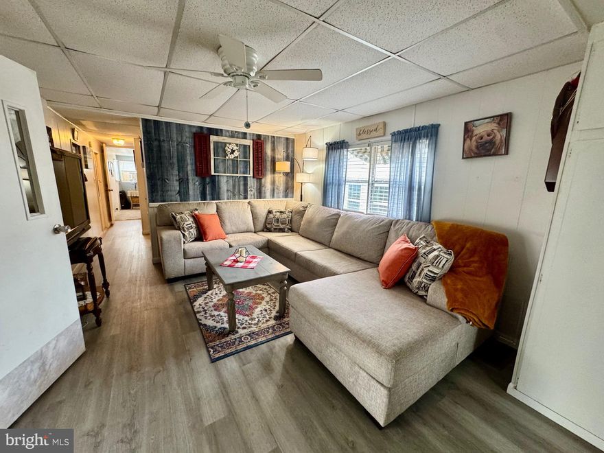 Cozy Charm Meets Modern Updates!  Don't let the "cute" exterior fool you—this home is deceptively spacious. Featuring a massive family room extension perfect for game nights and gatherings, this 2-bedroom  1.5 bath home has been thoughtfully refreshed. Enjoy brand-new luxury vinyl plank flooring throughout the main living areas, updated plumbing in the kitchen, and a bright, enclosed porch with new windows. Half bathrooms feature modern "comfort" upgrades, making this move-in-ready gem a must-see.  This home has central air and oil heat to keep you comfortable no matter the season. You will truly enjoy your time here with the great outdoor space, paver patio, and outside shower. The driveway will hold 4 cars so there is plenty of parking! This park has a playground area, club house, basketball court, dog park, and a spacious outdoor pool. Don't have a car, we have that covered too as the bus is a short walk outside the community.  The amenity rich community features a clubhouse, basketball court, dog park, fitness room, swimming pool, and a playground and the monthly fees include lawn mowing, snow removal, water and trash too.
