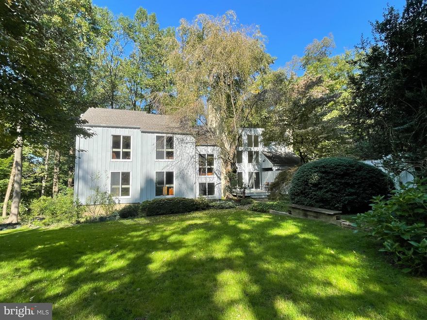 Modern. Private. Open.  And on the park!  First time offered for sale, this sophisticated four bedroom, four bath house was designed and built by the architect/owner as his family's primary residence.    Located in one of the quietest and most private locations in the neighborhood, yet you can still walk to the commercial district of Chestnut Hill, commuter rail stations,  and local schools.  In keeping with the modern esthetic, the house sits in the landscape so as to take advantage of the outside and nature  from every room.  Bordering the Wissahickon Valley of Fairmount Park,  the house is enveloped in a sea of green during the warm months. During the winter months, the views across the ravine are long and dramatic.  From the circular driveway, enter a spacious foyer with large coat closet.  As you walk from the entryway into the large living room, the ceilings vault,  a wall of windows displays the grandeur of nature beyond, and the warm-toned finishes of the interior echo the woodlands outside.  On one side , the living room has sliders to a wooden deck and lovely level garden.  There is a wood-burning fireplace that serves as the centerpiece of the space.  At either end of the living room are two flexible spaces.  Used as bookend offices by the current owners,  the rooms are easily reimagined to suit the next owner's needs.    Completing the entry level floor are two bedrooms and two baths.  One serves as the primary bedroom with "en suite" bath and wall of closets.  Head downstairs to the kitchen and dining room, with three doors out to the patio, a wood-burning stove,  a large laundry/mudroom,  and a large storage closet with utilities.  The cook's kitchen can hold all those who always end up in the kitchen, and has so much storage you'll never have to  pass on another gadget.  The floor also has a full bathroom.  Heading back up stairs to the third 
level, you find two more bedrooms and another full bath.  Come visit and imagine how you would live in this modern retreat.