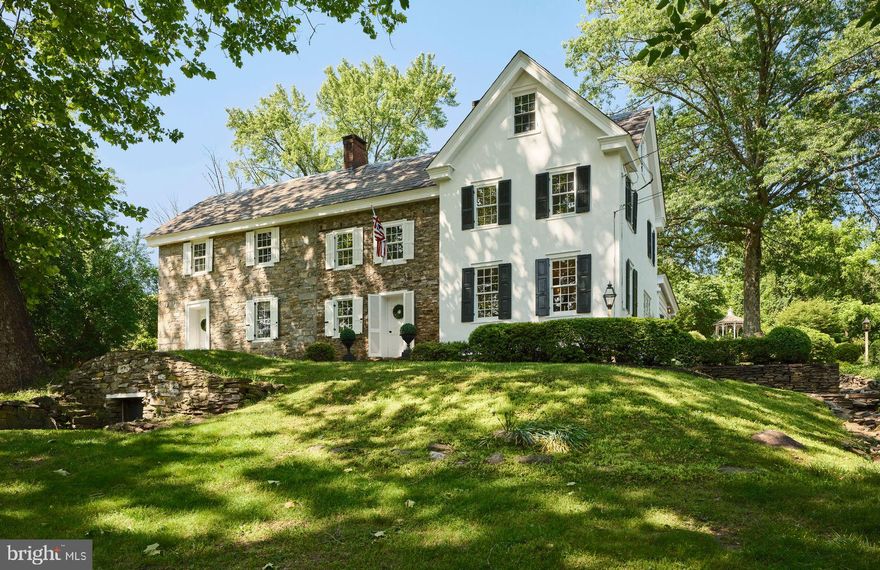 Welcome to Hillside Farm, a beautifully preserved Bucks County fieldstone farmhouse that offers timeless charm, thoughtful updates, and a peaceful, park-like setting. Along a scenic stretch of Washington Crossing, this gracious home combines character-rich architecture with modern comforts for everyday living and effortless entertaining.

Inside, authentic period details abound, from exposed beams and heart pine floors to walk-in fireplaces, an elegant staircase, and custom woodwork. The spacious, sun-filled kitchen features artisan-crafted cabinetry, stainless steel appliances including a GE Café double oven, and gracious farmhouse sink.   It flows seamlessly into a formal dining room and an impressive two-story great room.  The Great Room features the home’s original exterior stone wall and impressive window walls with a full-length window seat. French doors lead out to a herringbone patterned brick patio.

The cozy tavern room with a walk-in fireplace is perfect for chilly evenings, while the living room’s raised-panel mantel, beamed ceiling, and original double-hung windows add warmth and charm. Upstairs, the serene primary suite offers a fireplace, ensuite bath, and lovely garden views. Additional bedrooms include a flexible-use library with built-ins and a unique overlook into the great room.

Outside, the home is surrounded by mature gardens, heirloom plantings, and historic outbuildings, including a gazebo, springhouse/root cellar, writer’s cottage, and a 2-bay garage. The four-zone heating and two-zone AC systems provide comfort year-round.

While Hillside Farm is a tranquil retreat, it also holds a remarkable place in American history. Built around 1806 by James Henry Slack, a Revolutionary War veteran and early abolitionist, it later became the birthplace of Civil War General James Richard Slack and home to railroad historian Edward P. Alexander. The property has received a Preservation Award and has hosted numerous community events and garden tours. The property is not subject to conservation.

Centrally located near Newtown, New Hope, and Princeton, the location provides easy access to Philadelphia, New York, and regional rail. Hillside Farm offers a rare opportunity to own a legacy home where history and gracious living beautifully meet.