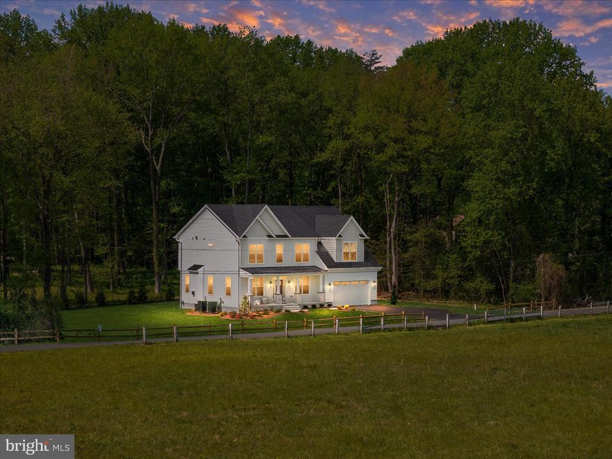 From the moment you arrive, there is an immediate sense of home—open space, fresh air, mature trees, and beautifully landscaped grounds create a setting that feels both private and expansive, with generous distance between neighboring homes and a peaceful estate-like presence that is increasingly rare. Set on 2. and a half acres in one of Crownsville’s most desirable settings, 1252 Sunrise Beach Road presents a compelling opportunity to own a newly built custom residence paired with a fully permitted -move in ready -guest cottage—an offering that seamlessly blends luxury, flexibility, and long-term value. Crafted by Cedar Square Homes, the main residence is a refined Modern Craftsman showcasing exceptional quality and thoughtful design throughout, where stellar moldings and trim work, tall windows, and oversized doors create a dramatic and handsome presence from room to room. With 9’ ceilings on both the first and second levels, walls of windows fill the home with natural light, while luxury barn plank flooring extends across the entire main level and into the upper hall and primary suite.  At the heart of the home, a true gourmet kitchen commands attention with high-end 42-inch white cabinetry, exquisite quartz countertops, and an oversized island designed for gathering, complemented by a wet bar with wine refrigerator and chef grade appliances. The home offers both a formal dining room—elegant and perfectly suited for hosting—and a light-filled breakfast nook for more casual, everyday living. The adjoining living room provides warmth and comfort with a gas fireplace, while a separate sitting room offers the perfect space for a den, library, or quiet retreat.  Upstairs, the grand primary suite offers a private retreat with a spacious walk-in closet and a spa-inspired bath featuring a deep soaking tub and walk-in glass shower, while three additional bedrooms provide comfort and versatility. A thoughtfully placed second-floor laundry room adds everyday convenience. The finished lower level expands the living space with a recreation room, full bath, and a fifth bedroom—ideal for guests, extended stays, or flexible living needs. Every element reflects the advantages of new construction, including 30-year architectural shingles and the confidence of a full builder warranty.  Beyond the walls of the home, the property truly comes to life. Expansive, level grounds offer endless possibilities for outdoor living—summer gatherings, cookouts, lawn games, and celebrations under the open sky, with ample space to create your own private retreat, including the potential for a future pool or outdoor kitchen.  The guest cottage is equally impressive, offering three bedrooms, two full baths, a full kitchen, its own laundry, and a charming front porch—perfect for multigenerational living, guest accommodations, private office use, or income-producing potential. With no HOA restrictions, the possibilities here are as expansive as the land itself.  Ideally positioned with convenient access to major commuter routes including Rt. 50 and 97, and just minutes from Annapolis, as well as within easy reach of Baltimore, Fort Meade, National Security Agency, and Northrop Grumman, this location offers the perfect balance of tranquility and connectivity. This is a rare opportunity to secure a property that delivers immediate lifestyle appeal, exceptional quality, and enduring versatility—this is how life should be lived.