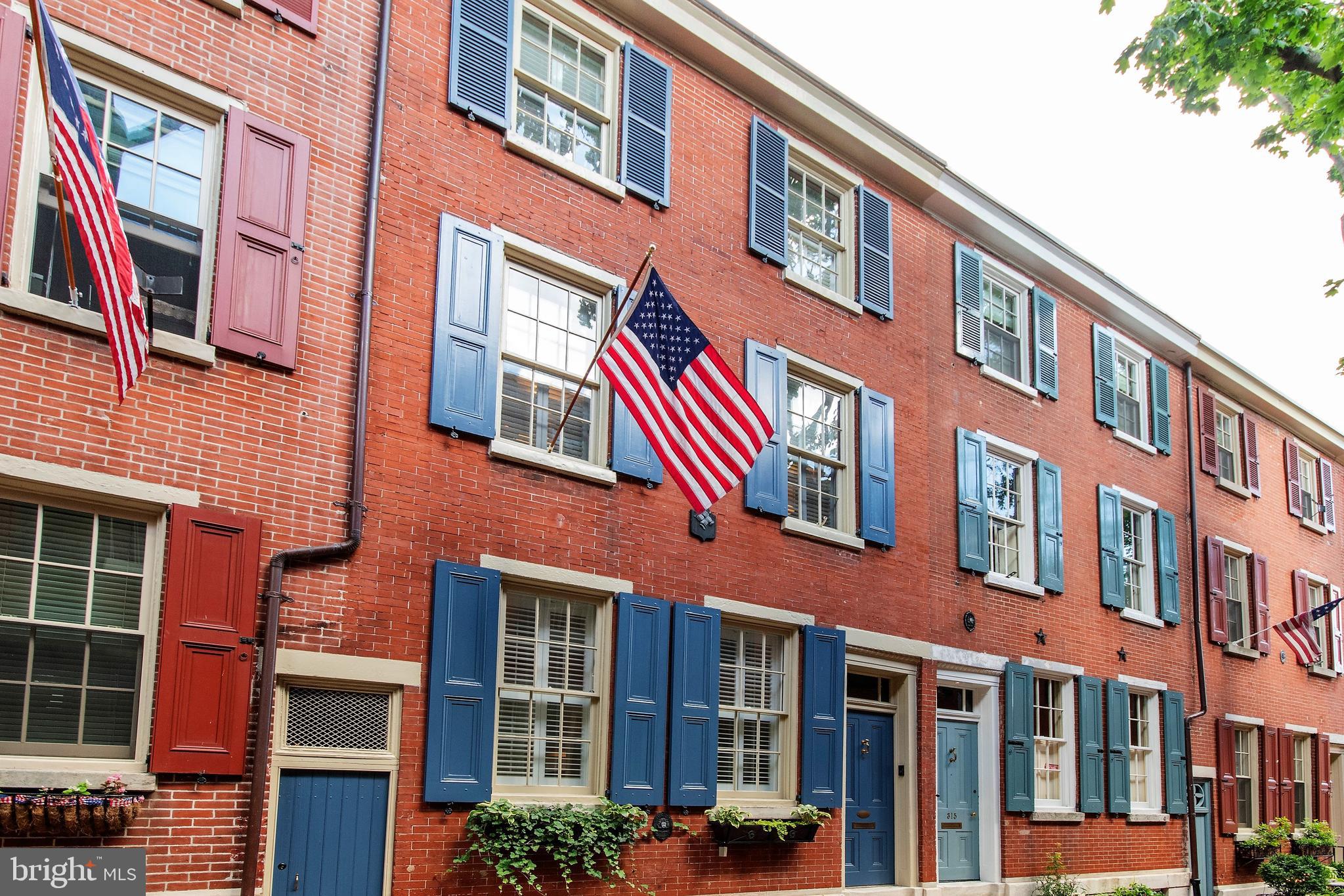 As you walk down American Street, soak in Philadelphia’s rich history as you walk over each and every cobblestone. This lovely Society Hill townhouse was originally built in 1847 and underwent renovations designed by award winning architect, Cecil Baker.  Baker created a two-story interior atrium space with a glass wall and palladium window.  On the historic exterior are new planter boxes at the front windows and original wood shutters that were rebuilt, stripped and repainted. SELLER OFFERING $5000 TOWARDS BUYER'S CLOSING COSTS WITH ACCEPTED OFFER!
As you walk up your front steps, enter into your foyer and to the left you will find a spacious living room with one of the four fireplaces in the home.  This fireplace is a new gas log vented fireplace that will cozy up this space right away. This room has new custom built-in Millwork bookshelves, media cabinet and a spacious coat closet.   There are recessed lights throughout the home and all wooden floors are original pine wood flooring. The living room overlooks one of the large glass walls Cecil Baker curated in the home.  In the evening the custom pendant lighting creates a special ambiance. Step forward to a sunny spacious den that has radiant heated floors and overlooks the outside space through a classic Baker glass wall.  This area could be perfect for a home office or cozy den where house plants would thrive.  
Turn the corner to go downstairs to your beautiful open concept kitchen and dining room with a new chef’s kitchen complete with new appliances such as a gas cooktop stove, electric wall oven, convection microwave combo, a unique bar/pantry storage with a custom walnut Millwork breakfast bar, along with LED downlighting throughout all the drawers and cabinets with lots of storage.  The fireplace on this level is wood burning with a new chimney line and new tile surrounded.  This fireplace is where the original cooking fireplace was when the house was first built.  There is a full built-in bar area on this level and it is cleverly tucked away behind an unassuming door! On this level of the home, the floors are heated to keep your toes warm and there is a half bathroom along with a glass door that leads out to a new patio which includes a new built-in gas grill with a natural gas hook up installed in 2017 and new flagstone & stone wall/planter. Head back up the stairs to the 2nd floor where you will find the main en-suite bedroom which includes a built-in closet system, dressing room, fireplaces, lots of storage and a  private terrace which this year had its pavers removed, cleaned and reinstalled after new roofing was installed beneath it!  The new main bath spa shower has heated floors and a heated towel bar along with all newer fixtures and Porcelanosa tiles. The fireplace in the bathroom/dressing room area is functional wood burning but has not been used during the current owner's time in the home and was recently retiled, in 2017.  Adjacent to the main bedroom is a new laundry room with Miele stacked washer/dryer and built in storage with a water safety shut off.  Head up to the 3rd level and you’ll find two bedrooms and a full bathroom.  The front bedroom has ample loft storage and a multiple-closet system.  The back room overlooks the outside spaces where you can look out to see the beautiful historic city.  This level also has stairs for roof access through a skylight where you will find your A/C and heating systems and a new coated roof.  This home is located in the heart of Society Hill near fantastic restaurants, retail and is just 1 block from Head House Square with great shops and a Sunday Farmers Market as well as Three Bears Park. The sellers lease a space very close to the home and will include 2 YEARS PRE-PAID parking & transfer of the lease with an acceptable Agreement. This home is beautiful and unique and in the heart of  historic Philadelphia.