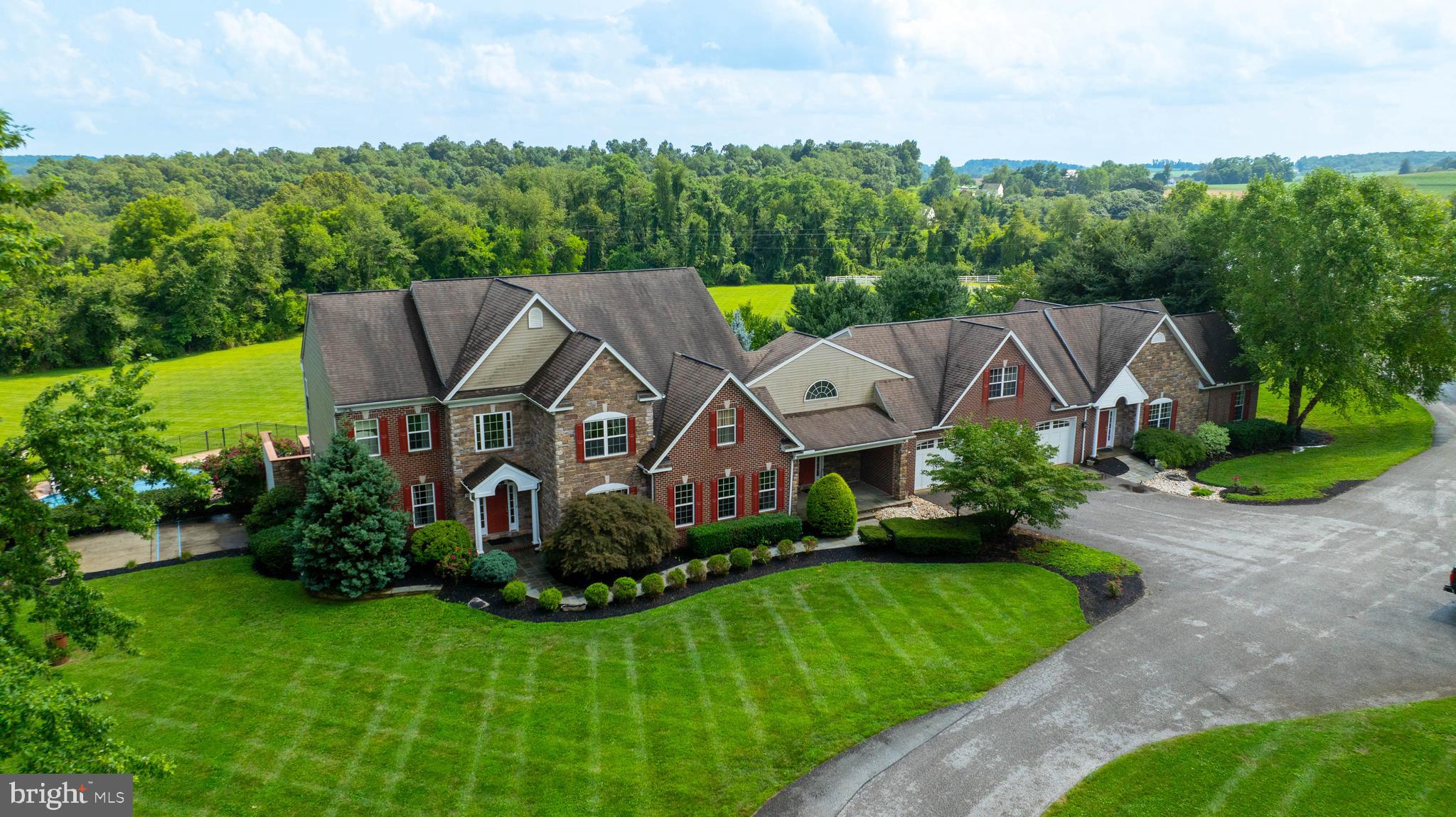 This exceptional 18-acre horse farm features a spacious estate exceeding 9,700 square feet of finished living space, complete with separate accommodations for in-laws. Nestled in a private setting, the property includes fenced pastures with a run-in shed, a 140’ x 70’ barn housing a 120’ x 70’ indoor riding arena and ten horse stalls, as well as a 60’ x 40’ shop and a 27’ x 32’ woodshop to support agricultural activities. The outdoor space boasts a large patio, an in-ground swimming pool with a pool house and gazebo area, and offers stunning views of lush greenery alongside a creek. This well-equipped property not only facilitates daily farm operations but also provides a move-in ready home with ample family space and luxurious features. The main level showcases beautiful hardwood flooring, a private office, and a great room with a cathedral ceiling, while the gourmet kitchen is equipped with a double oven, granite countertops, a breakfast area, and a center island. The upper level includes a master suite featuring herringbone hardwood flooring, a walk-in closet, and a luxurious bath designed for a spa-like experience, complete with a jetted tub and a dual-sided walk-in shower. The fully finished lower level offers a recreation room with a wet bar and pool table, a movie room, four additional bedrooms, and a full bath, creating a complete separate living area. An attached three-car garage connects the main residence to the in-law quarters, which includes a full kitchen, living and dining areas, two bedrooms, a walk-in closet with laundry hookups, and a handicap-accessible full bath, making this property a comprehensive and desirable estate.