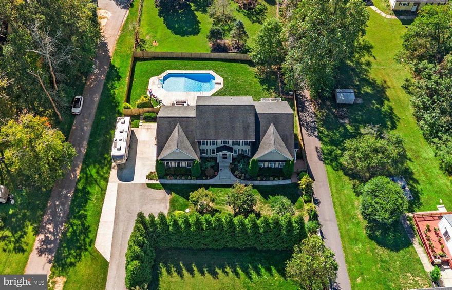 You’ll have more fun living here. Don’t miss this rare opportunity to own an expansive estate home offering nearly 7,000 square feet of living space, including a fully equipped in-law suite with its own private entrance.
A long driveway framed by mature evergreen trees creates a private, tucked-away feel as you arrive home. 
Step inside to a welcoming tiled foyer and a private home office with French doors, perfect for working from home or managing daily life. The kitchen is designed for both everyday living and serious entertaining. Warm finishes, stainless steel appliances, pendant lighting, and an oversized island with seating create a space where everyone naturally gathers. Hosting is effortless with two sinks, two dishwashers, and two refrigerators, making large meals and celebrations easy. The adjoining dining area offers a sunny spot for meals and provides access to the back patio. Just beyond, the kitchen opens to a cozy family room anchored by a striking stone fireplace, with windows on either side that fill the space with natural light.
The main-level owner’s suite offers convenience and comfort, complete with an adjoining full bath featuring upgraded tile, dual vanities, and a relaxing soaking tub. One of the home’s most impressive features is the private in-law suite, thoughtfully designed with its own entrance. This space includes a full kitchen, living room with fireplace, laundry room, two bedrooms, each with their own full bath, and a private deck overlooking the backyard and pool. It’s ideal for extended family, guests, or multi-generational living.
Upstairs, the home continues to impress with four spacious bedrooms connected by shared full baths, helping busy mornings run smoothly. A massive bonus room over the garage offers incredible flexibility as a media room, studio, playroom, yoga space, or additional living area. The finished lower level adds even more versatility, featuring high ceilings, a large recreation area with fireplace and bar, walk-up access to the backyard, a full bath, and a separate room that could easily serve as a bedroom, gym, meditation space, or hobby room. You’ll also find plenty of unfinished storage space on this level. Get ready to have the best summer of your life! The level, fully fenced yard features an in-ground pool, patio, deck, and fire pit, creating the perfect setting for pool parties, gatherings with friends and family, or relaxing evenings at home. This is a home designed for living well, entertaining often, and making memories for years to come. Welcome home.